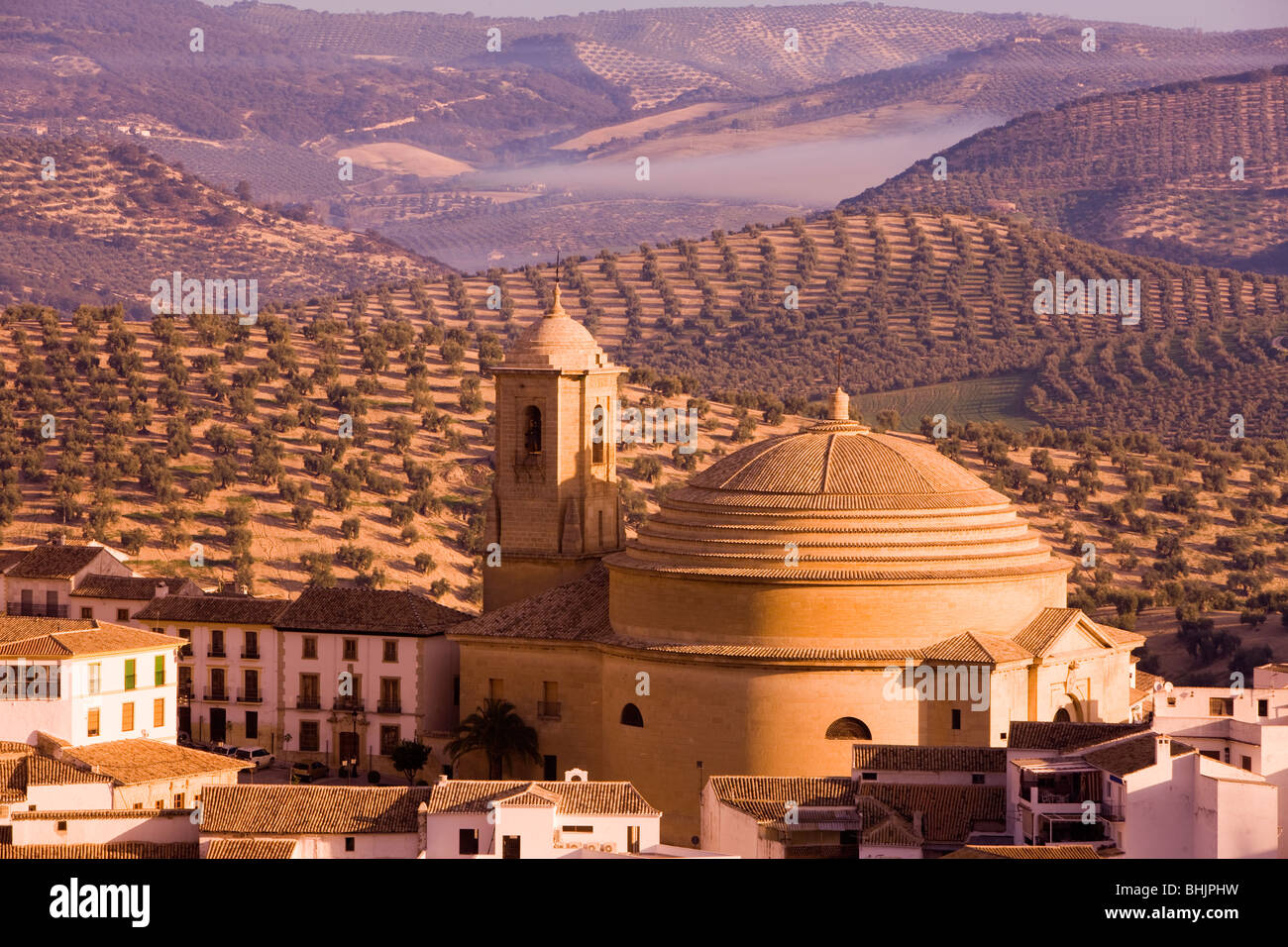 Spain Andalucia montefrio Elevated view of town church and surrounding olive fields in golden morning light Stock Photo