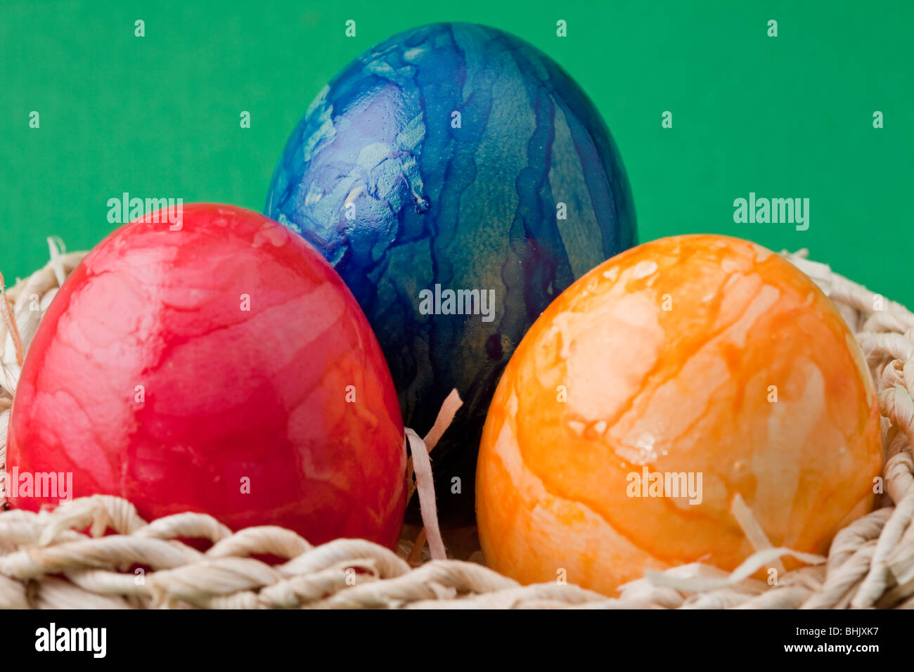 Three Easter Eggs in a Basket Drei bunte Ostereier in einem Korb Stock ...