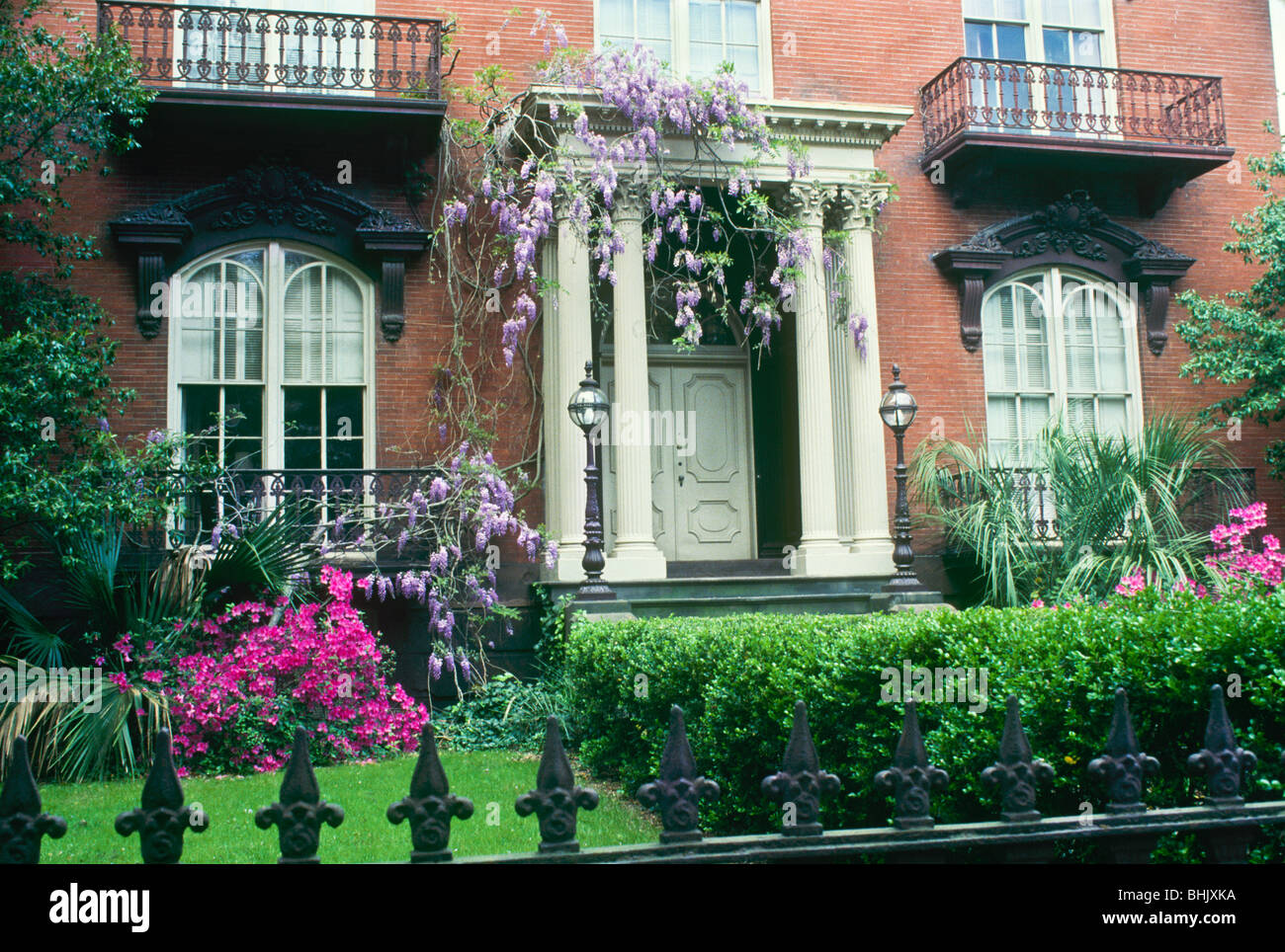 Historic Mercer-Williams brick house in spring with blooming wisteria and azaleas, Savannah, GA Stock Photo