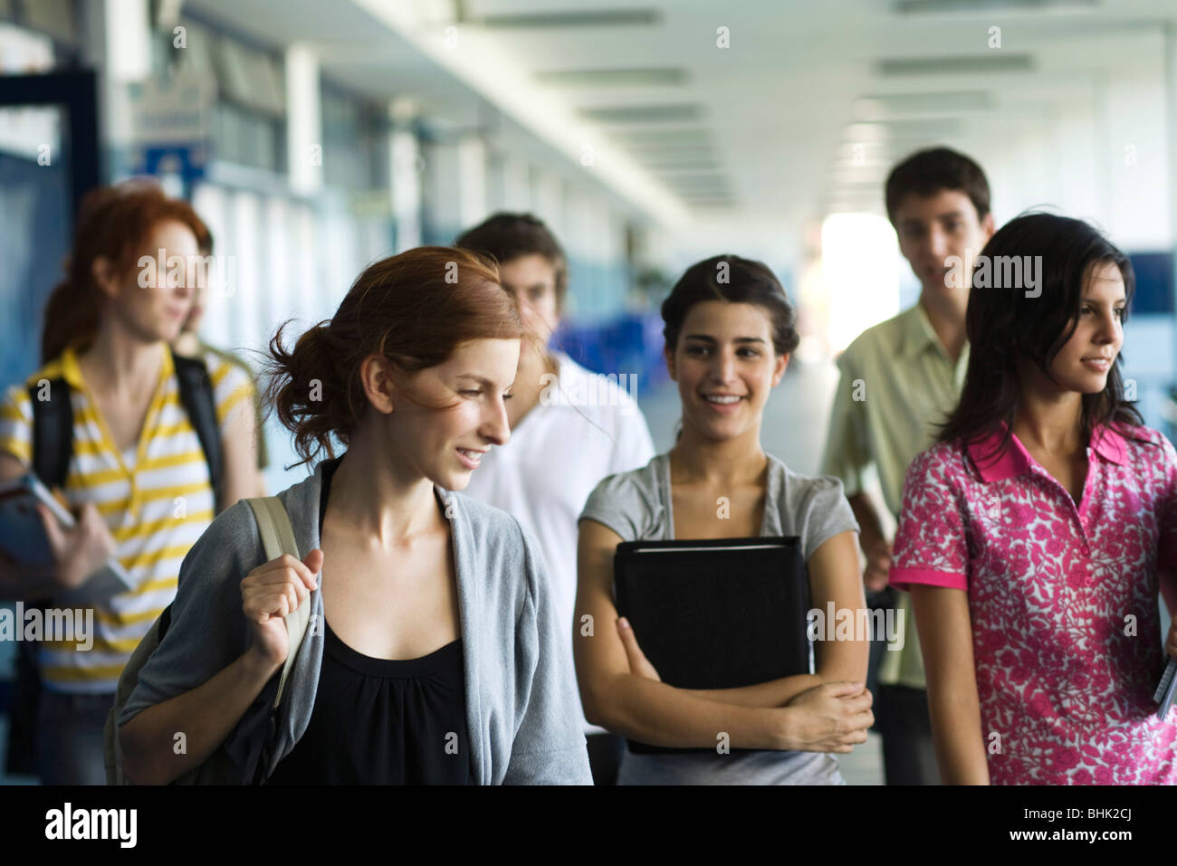 High school students walking along school corridor together Stock Photo ...