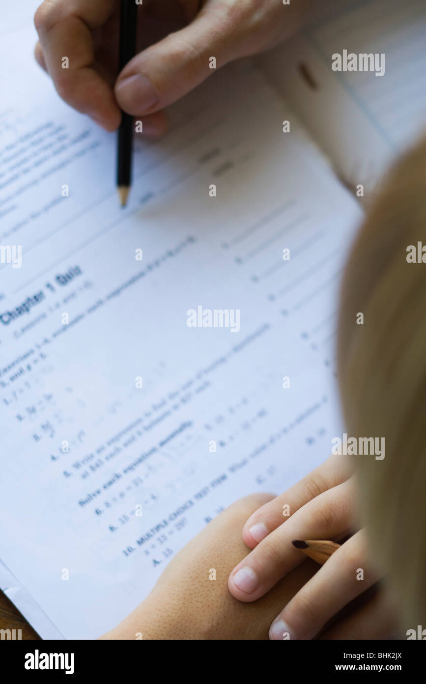 Student watching as teacher corrects quiz, close-up Stock Photo