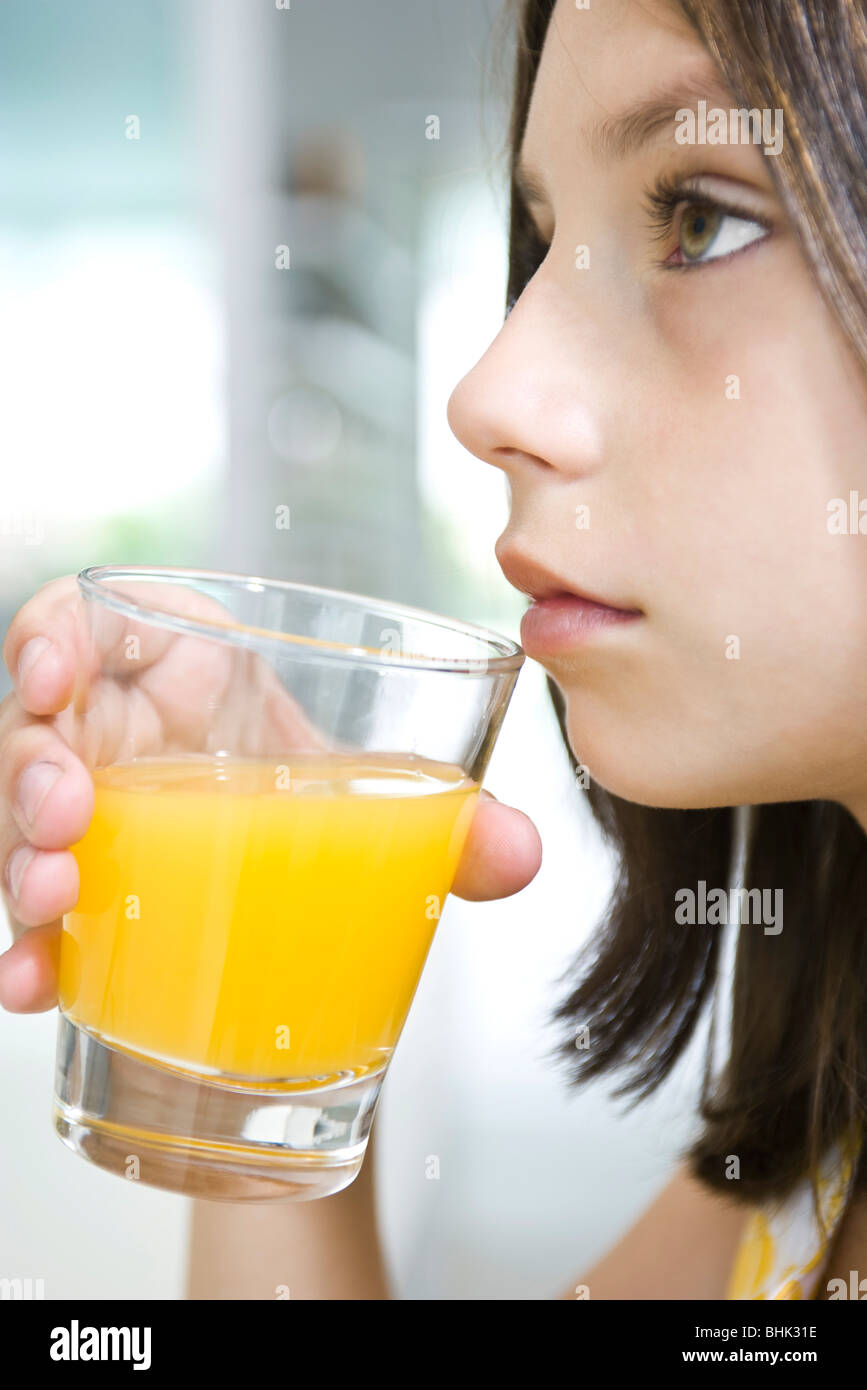 Girl drinking glass of orange juice Stock Photo