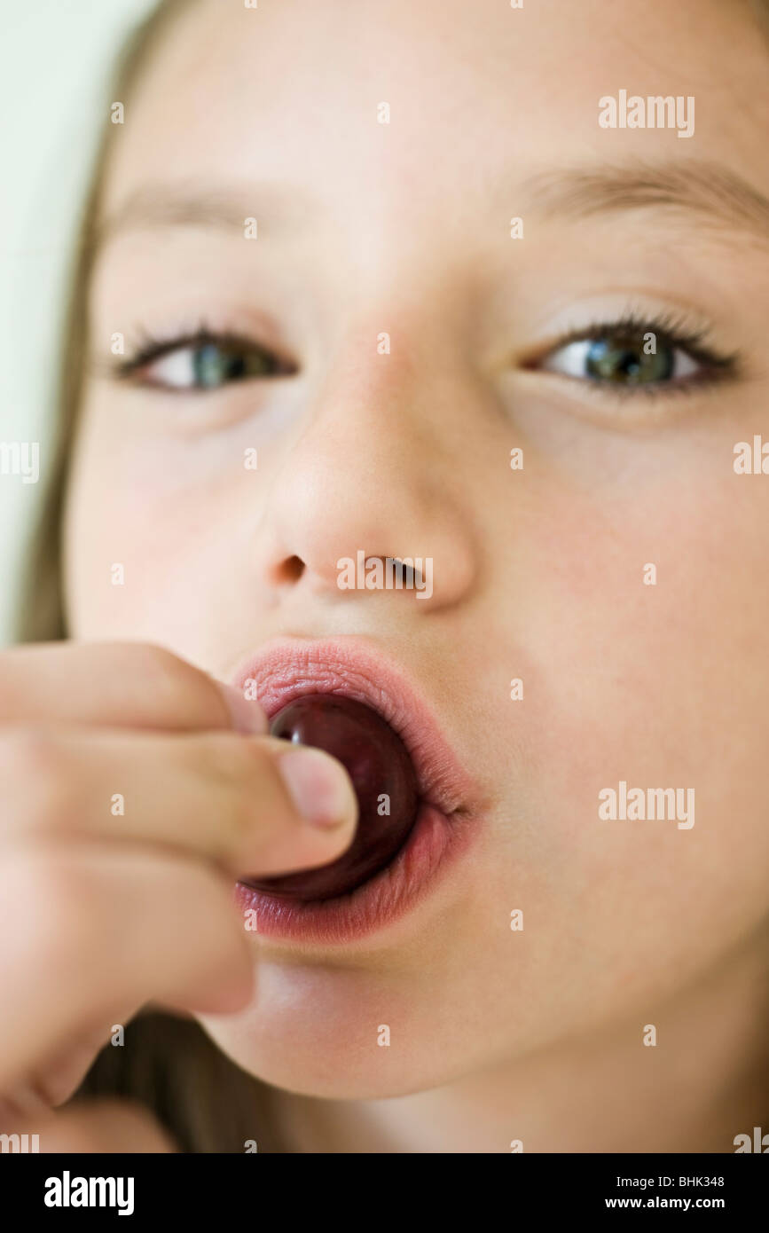 Girl eating cherry, close-up Stock Photo