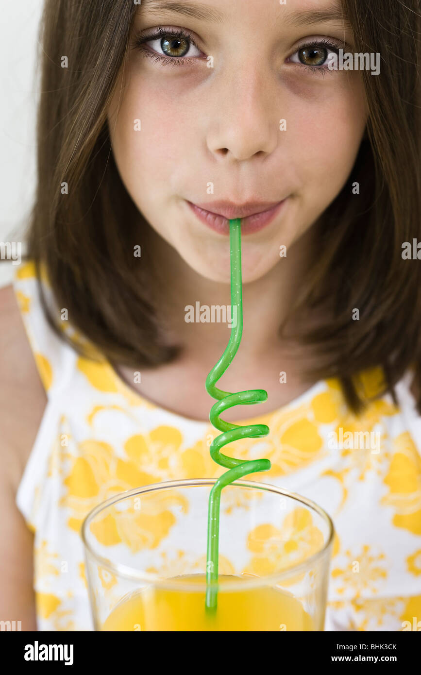 Girl drinking juice through curly straw Stock Photo Alamy