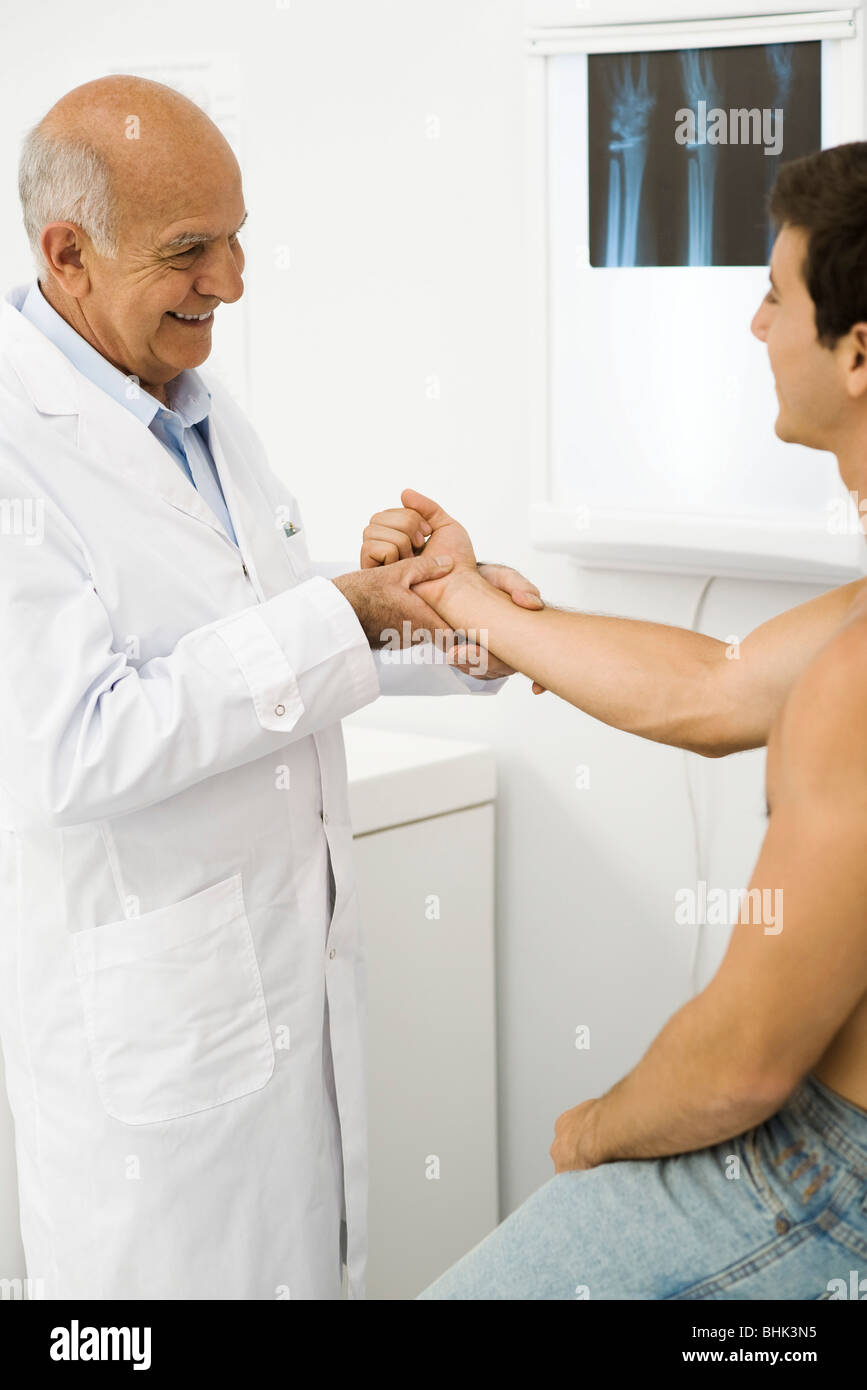 Doctor examining patient's wrist Stock Photo