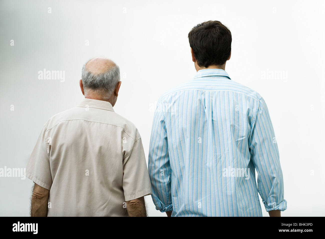 Senior man walking with adult son, rear view Stock Photo