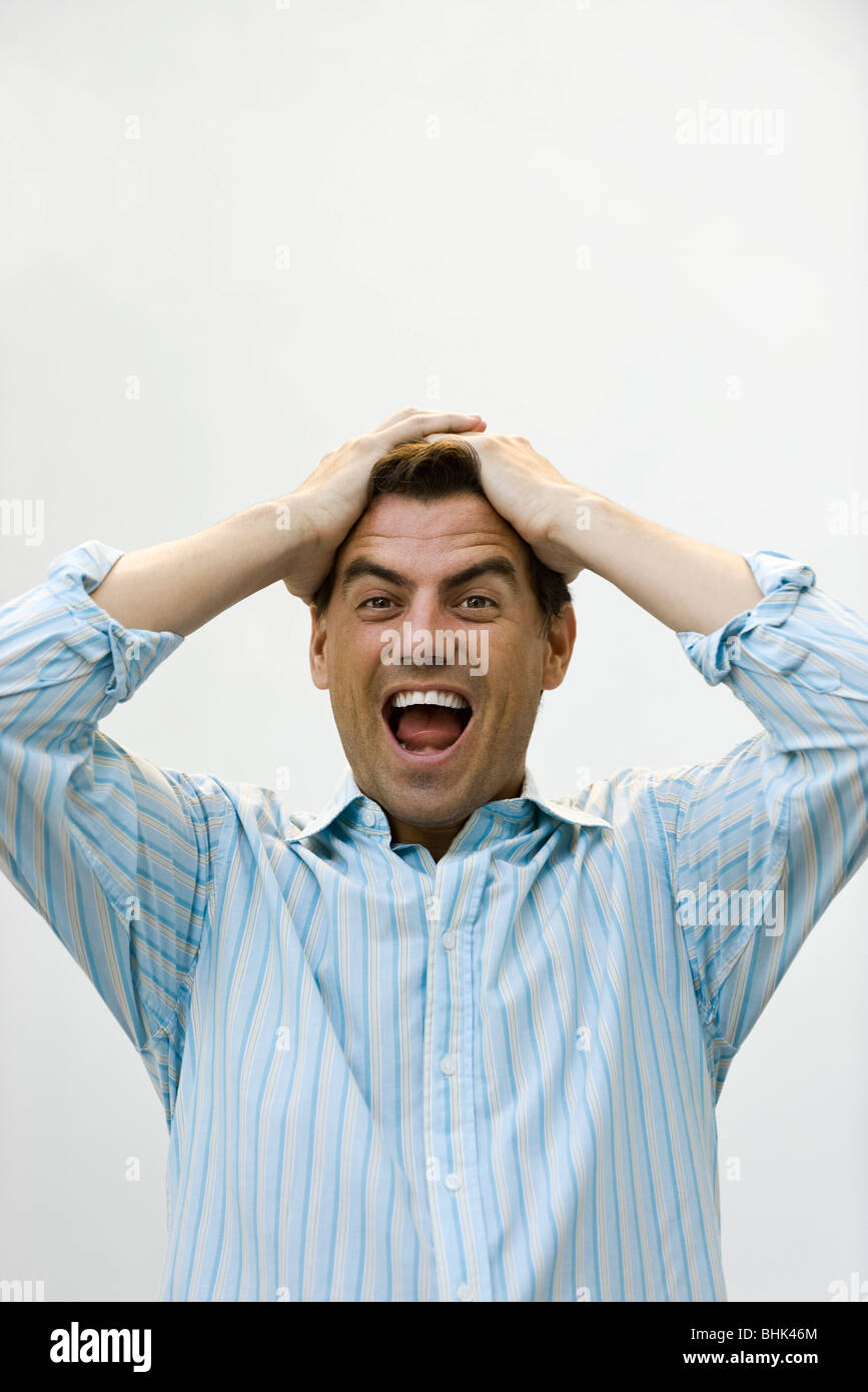 Man holding head screaming Stock Photo