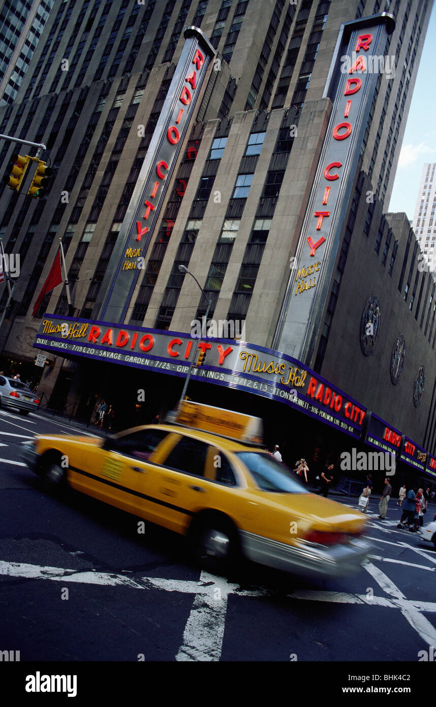 Manhattan, New York, USA. Yellow cab driving past Radio City Music Hall. Stock Photo