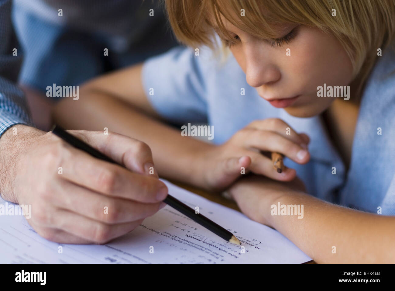 Elementary school student being helped by teacher in class Stock Photo