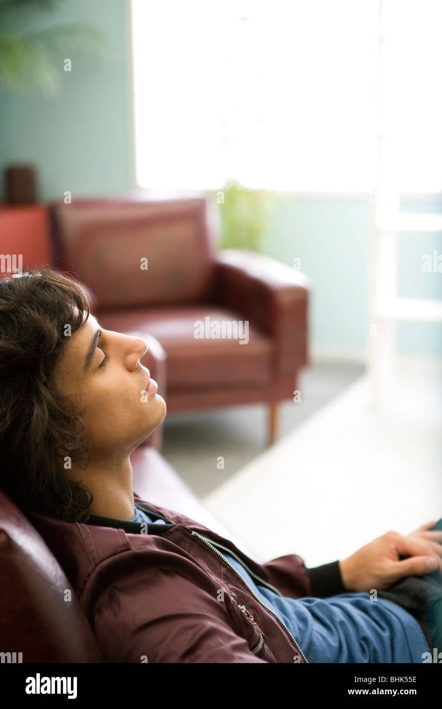 Young man relaxing on sofa Stock Photo