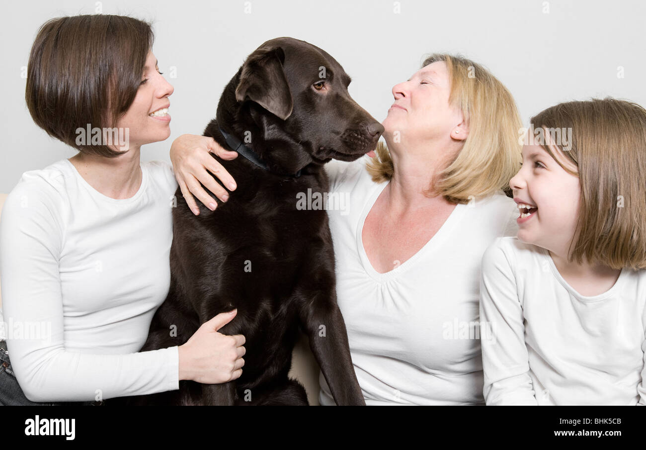 Shot of Three Generations of a Family Laughing with their Dog Stock Photo
