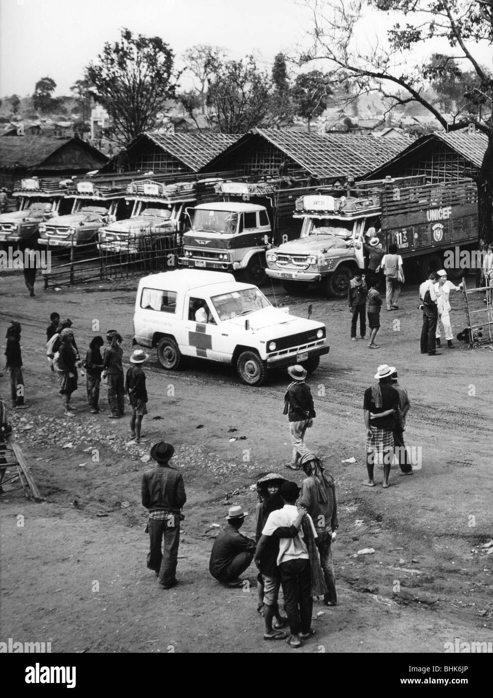 politics, international organisations, United Nations, UNICEF lorries, used to supply people from Cambodia with rice, at a gathering point, near Aranyaprathet, Nong Chang, Thailand, 1973, in the foreground a Red Cross vehicle, Stock Photo