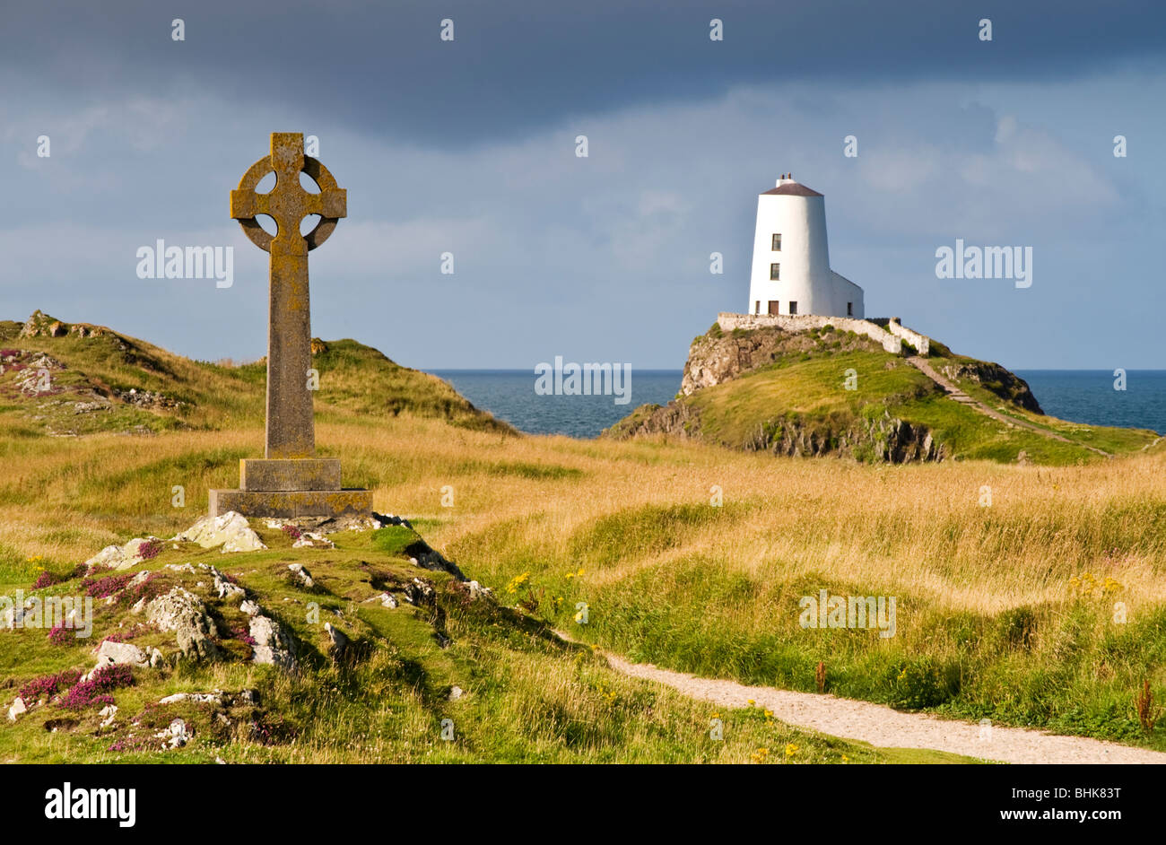 Stone Cross and Lighthouse on Llanddwyn Island National Nature Reserve, Near Newborough, Anglesey, North Wales, UK Stock Photo