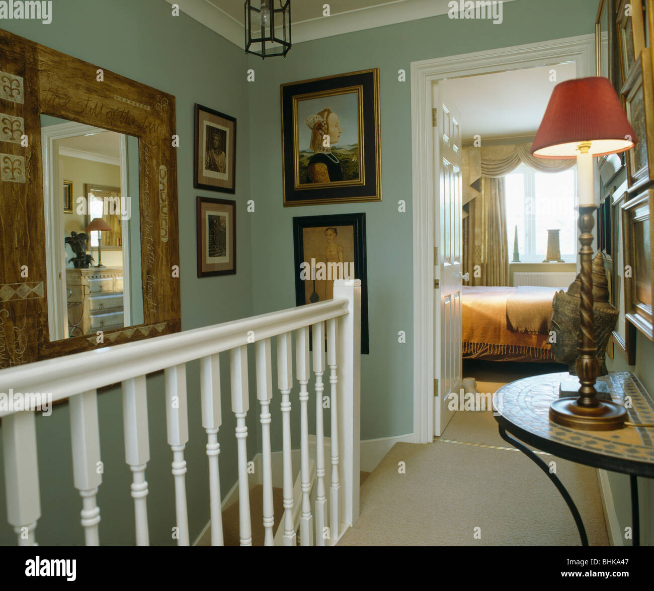 Pictures And Large Mirror On Walls Of Pale Green Landing
