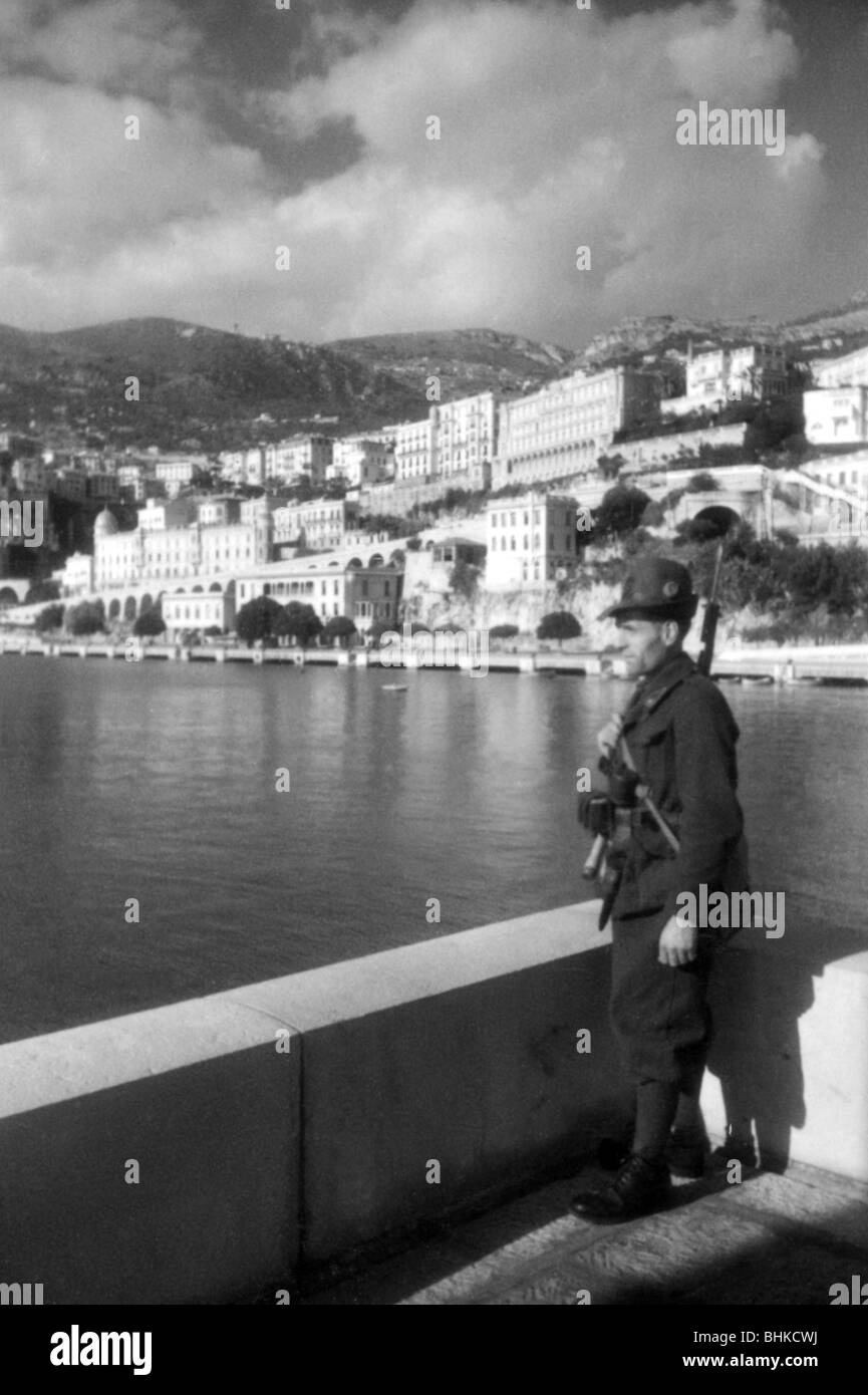 geography / travel, Monaco, politics, Italian and German occupation 1942 - 1944, Italian soldier on sentry duty at the coast, probably May 1943, Italy, Second World War, WWII, 20th century, military, uniform, uniforms, historical, historic, city views, cityscapes, houses, principality, full length, 1940s, people, Stock Photo