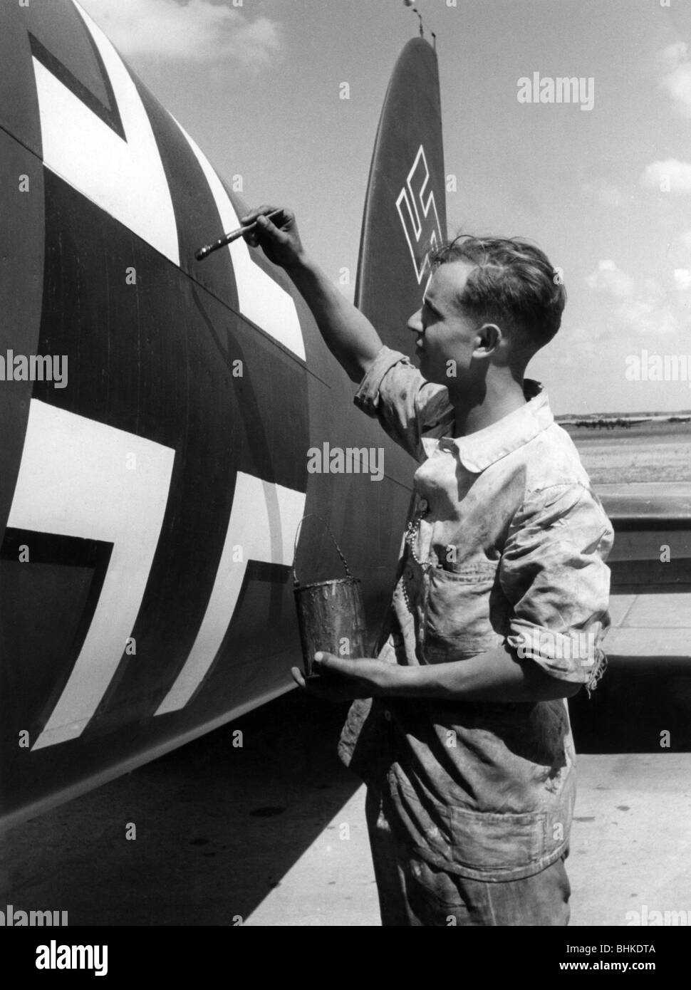 events, Second World War / WWII, aerial warfare, aircraft, details / interiors, German Luftwaffe soldier painting the Balken Cross on the fuselage of a medium bomber Heinkel He 111, circa 1940, Stock Photo