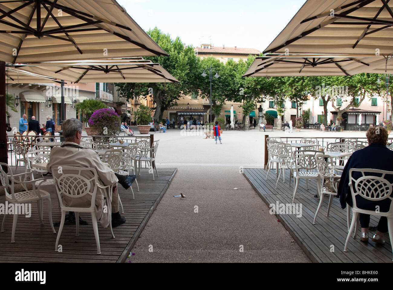 Piazza in the spa town of Casciana Terme Tuscany Italy, with a view through the bar awnings and children playing in the square Stock Photo