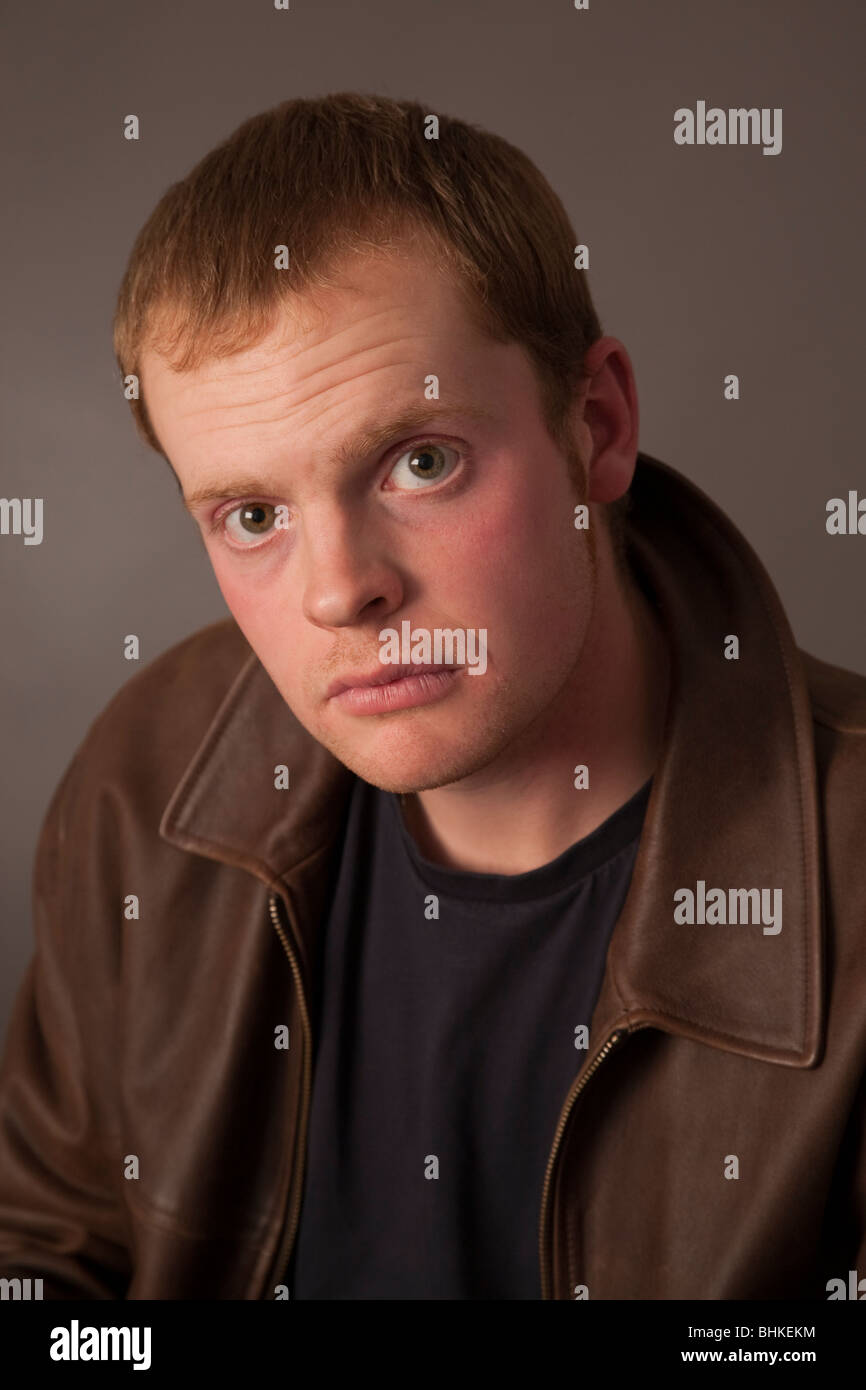 A young man in his twenties with a worried inquiring expression Stock Photo