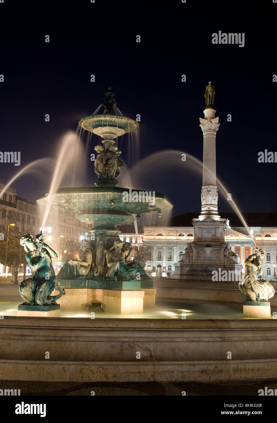 Portugal Lisbon fountains and statue in Pedro Square illuminated at night Stock Photo
