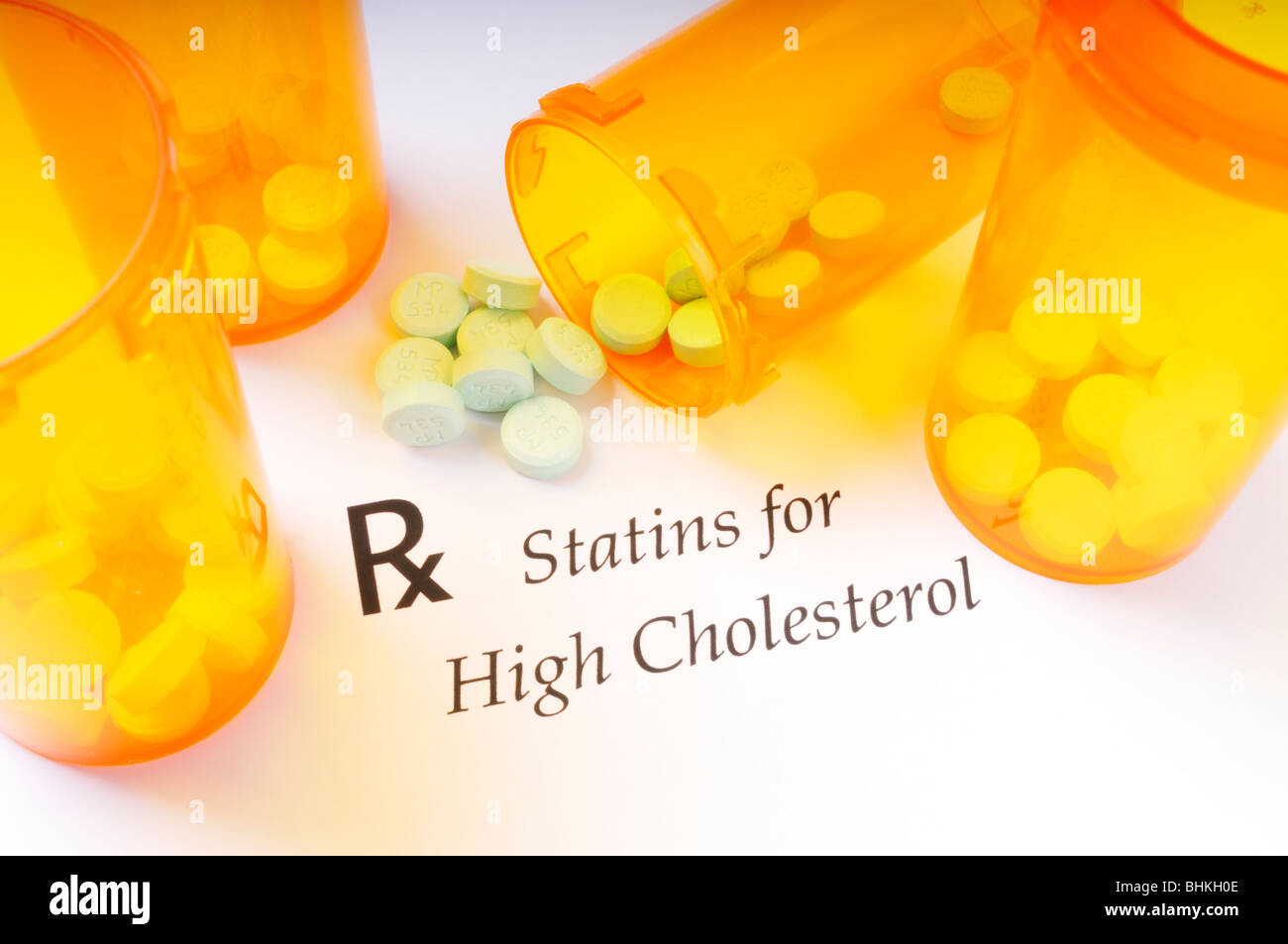 Prescription drug bottles and statin pills used for high cholesterol on white background. Stock Photo