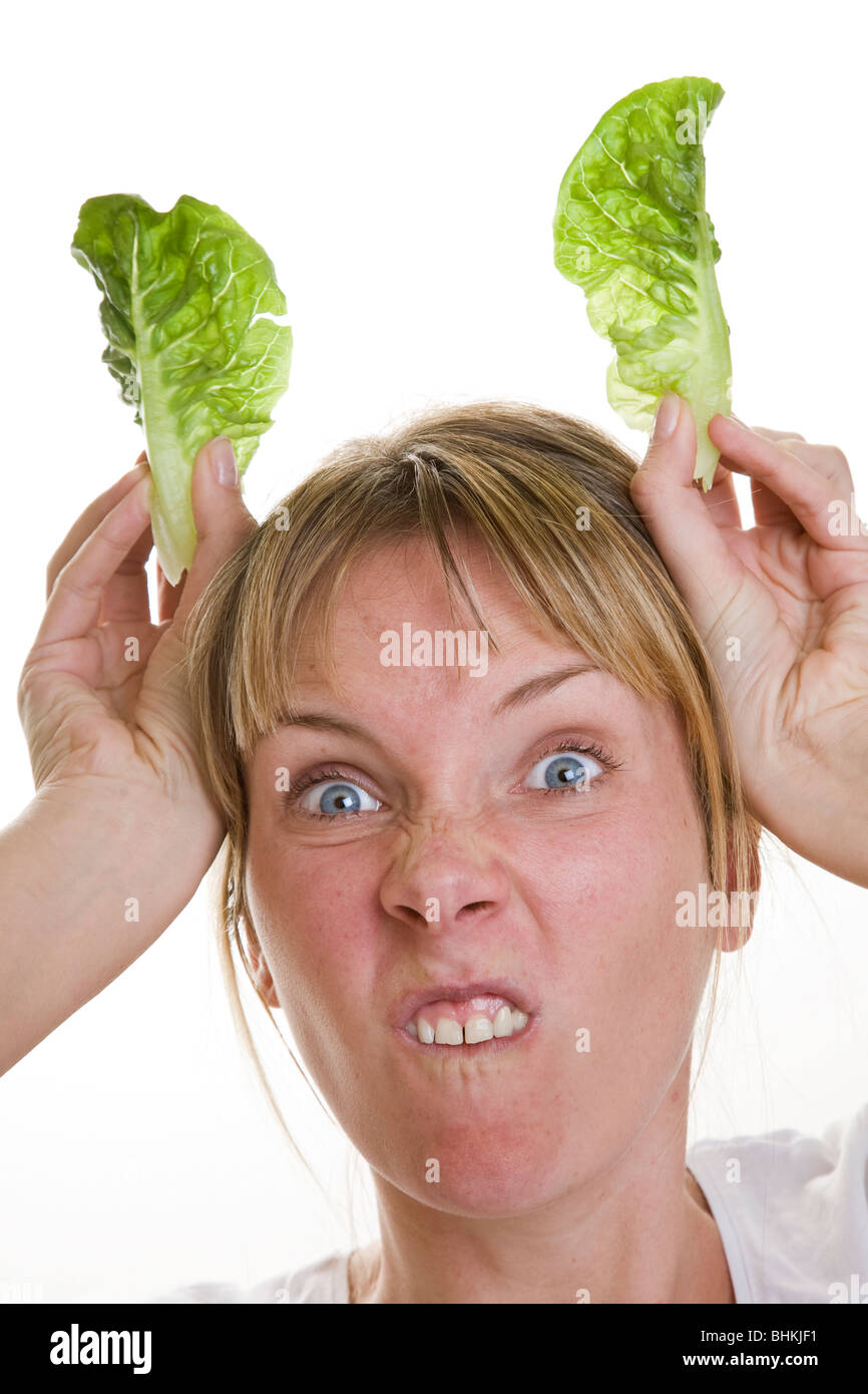 Woman with lettuce leaves for ears, pretending to be a bunny rabbit Stock Photo