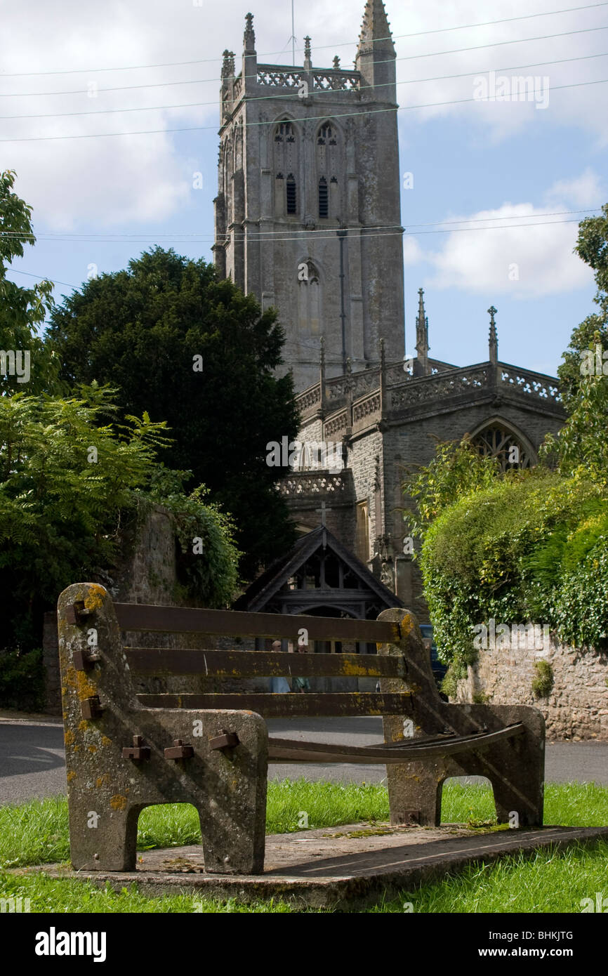 Village bench in front of church Stock Photo