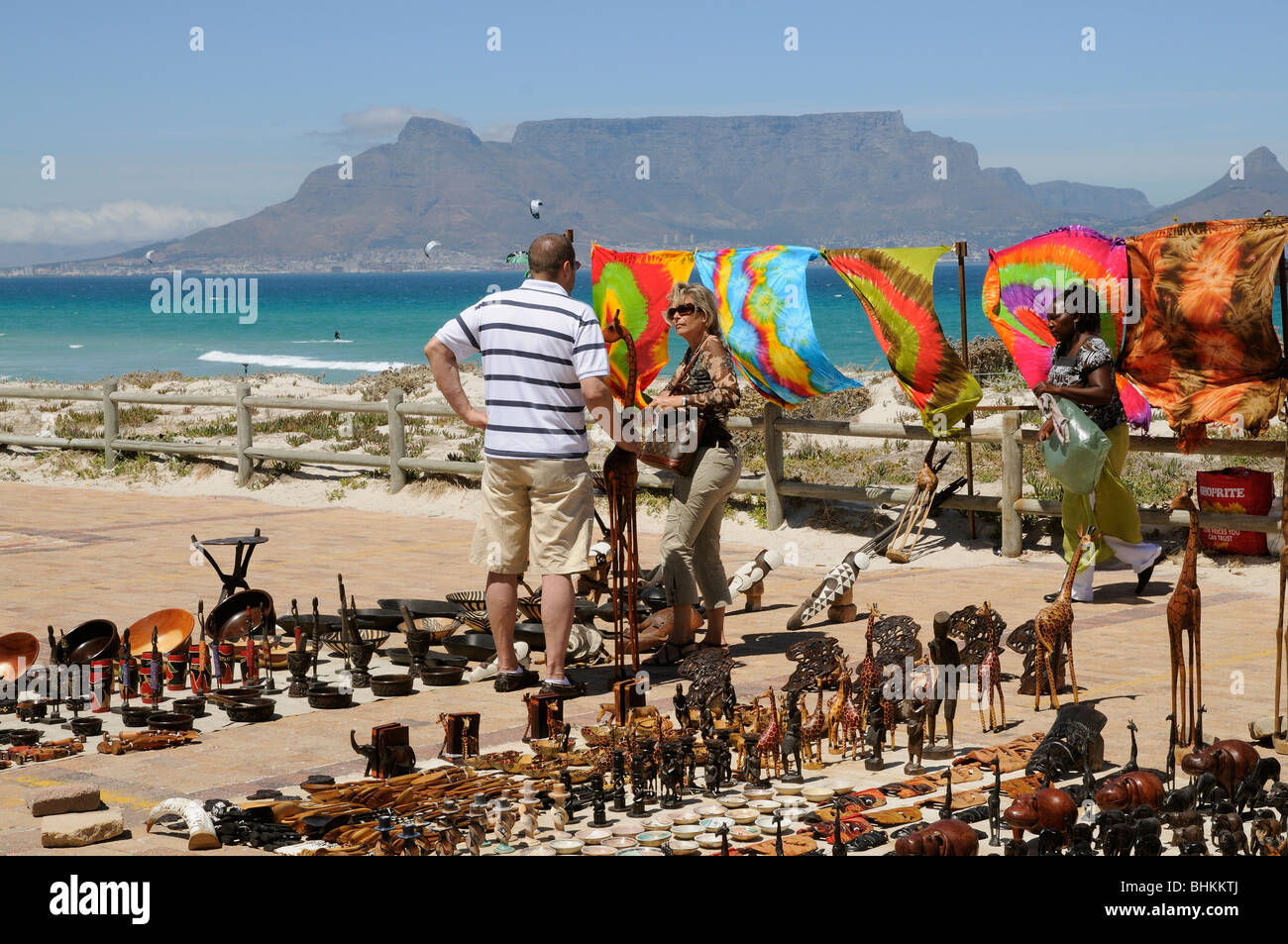 Tourists buying souvenirs from a trader at Sunset Beach Cape Town South