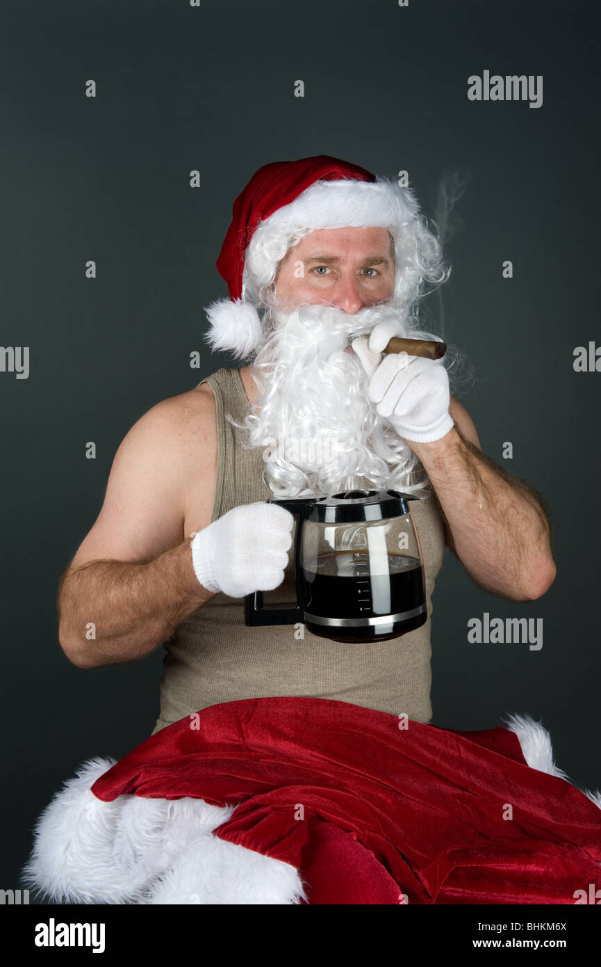 Santa Claus relaxing with a cigar and a hot pot of coffee Stock Photo