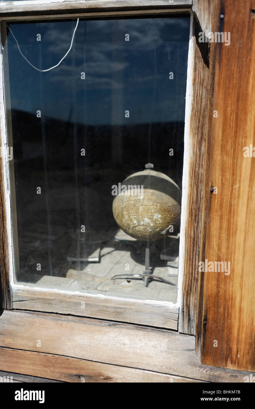 School House Window with a Decaying Spinning Globe Map, Bodie, California Stock Photo