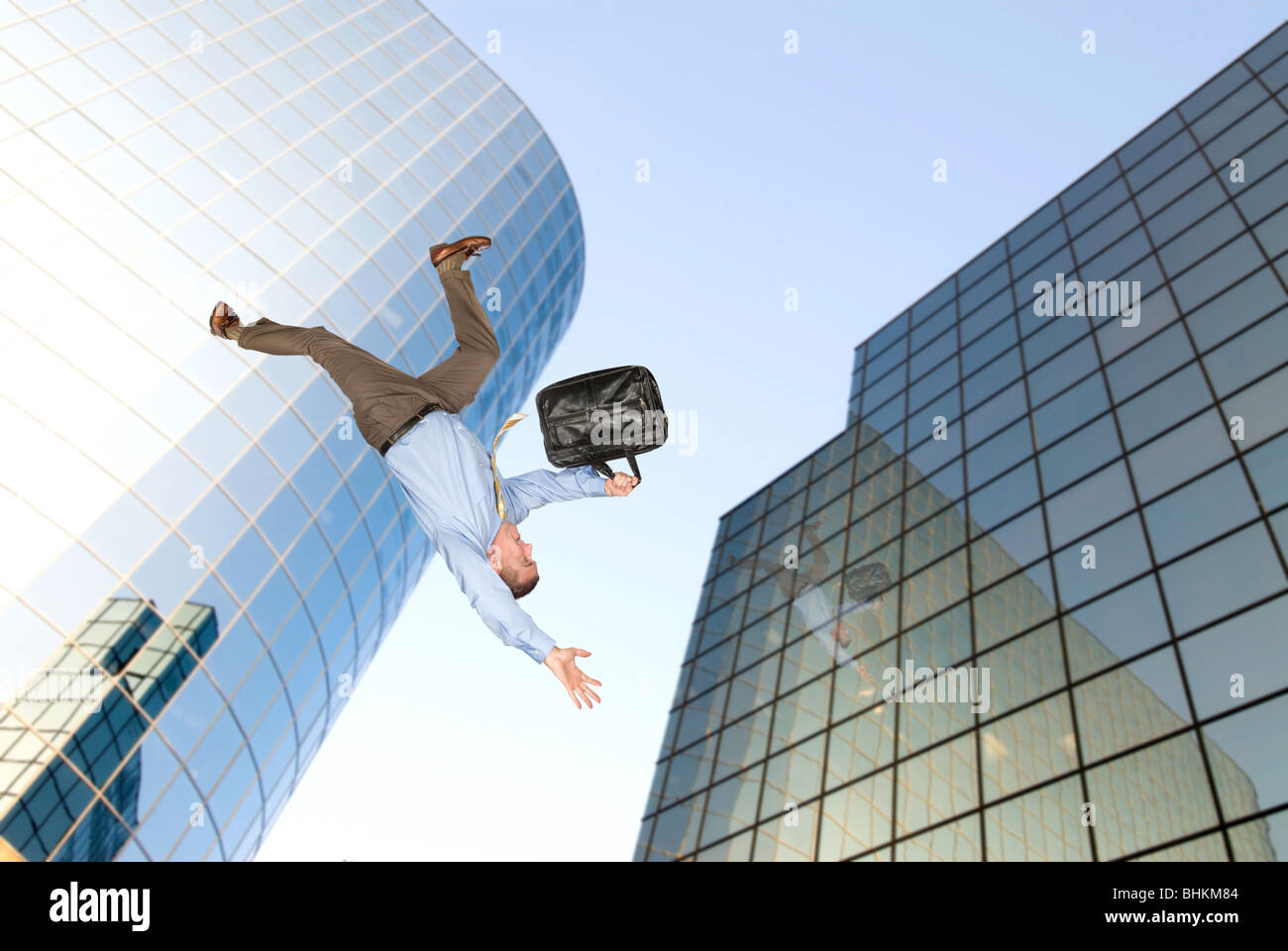 A businessman falls from a building rooftop after too much emotional stress at work caused him to commit suicide. Stock Photo