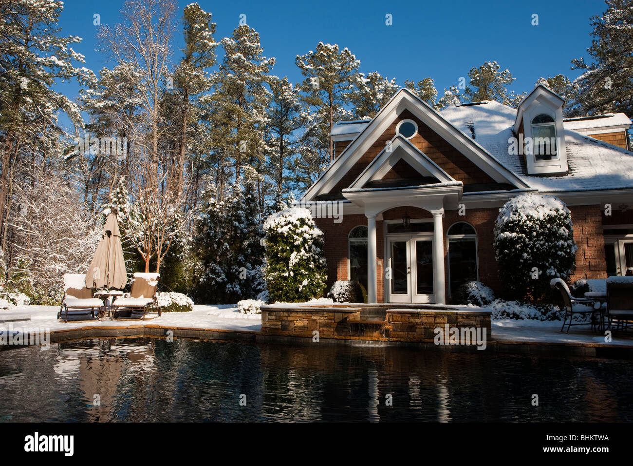 Pool House and swimming pool with blanket of snow morning after unusual southern climate winter snowstorm Southeast USA, Atlanta Georgia. Stock Photo