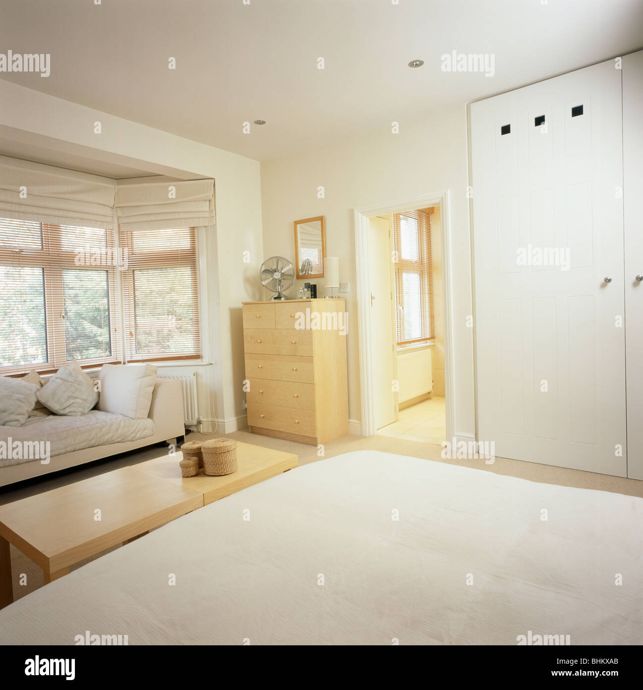 Pale Wood Table Below Bed In Modern Economy Style Bedroom With