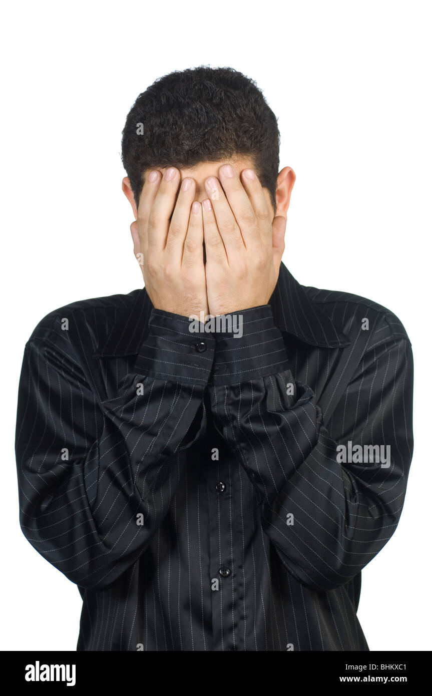 young man head in hands hiding his face standing against a white background Stock Photo