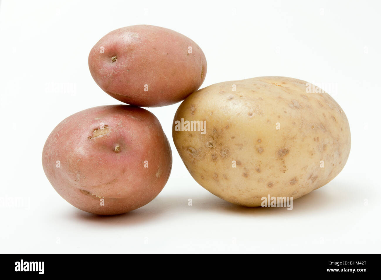 Zen like potato arrangement of three potatoes against white background. Stock Photo