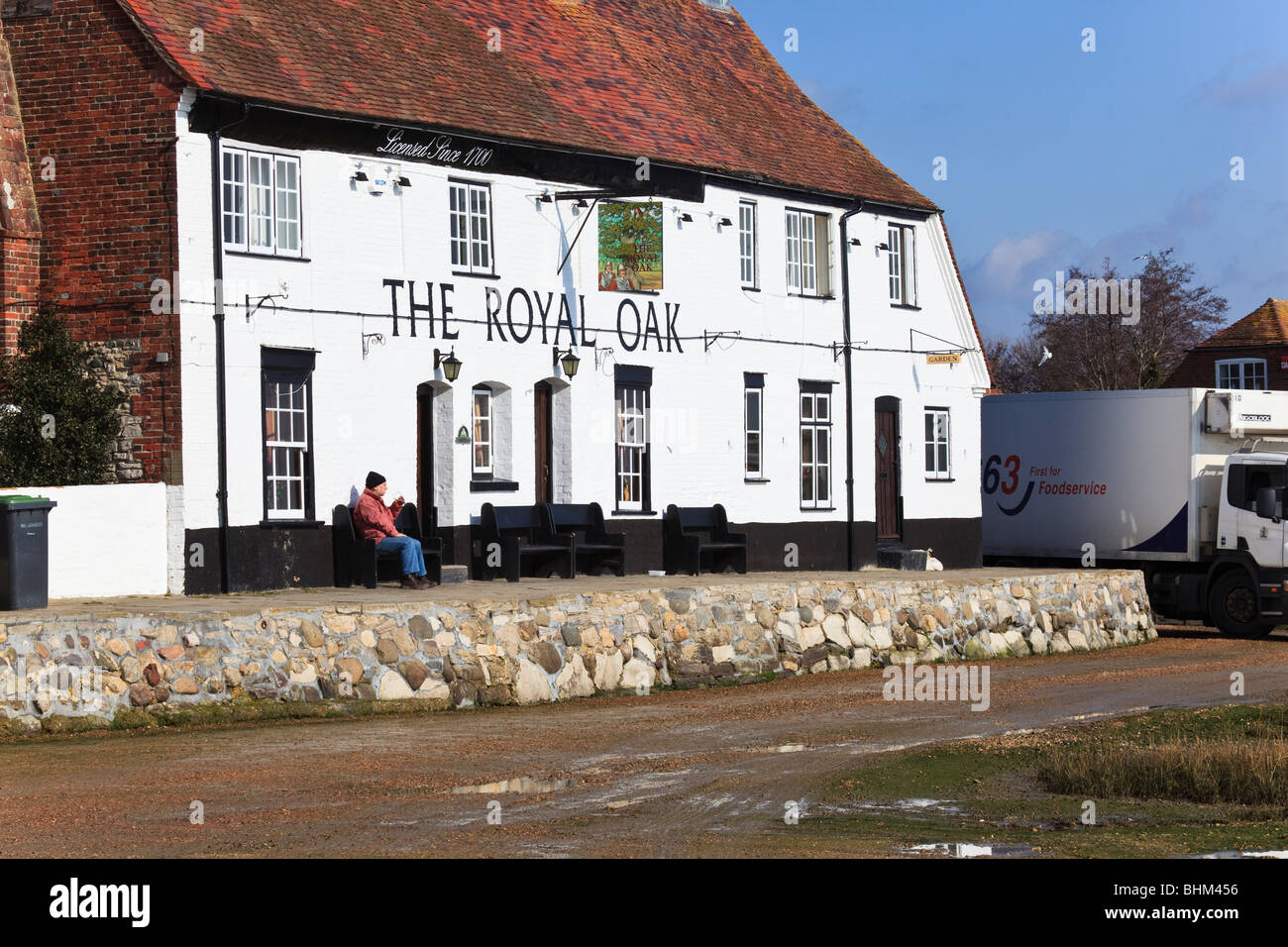 Customer outside The Royal Oak pub on the waterfront at Langstone, Hampshire, UK Stock Photo