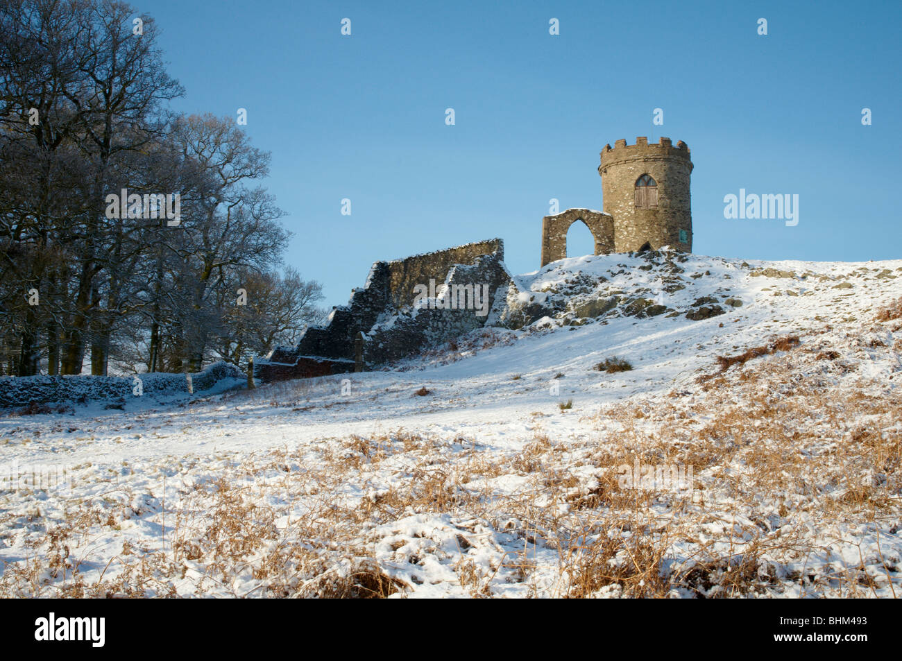 Snowy Winter Scene at Old John, Bradgate Park, Newtown Linford, Leicestershire. People having fun, sledging downhill. Stock Photo