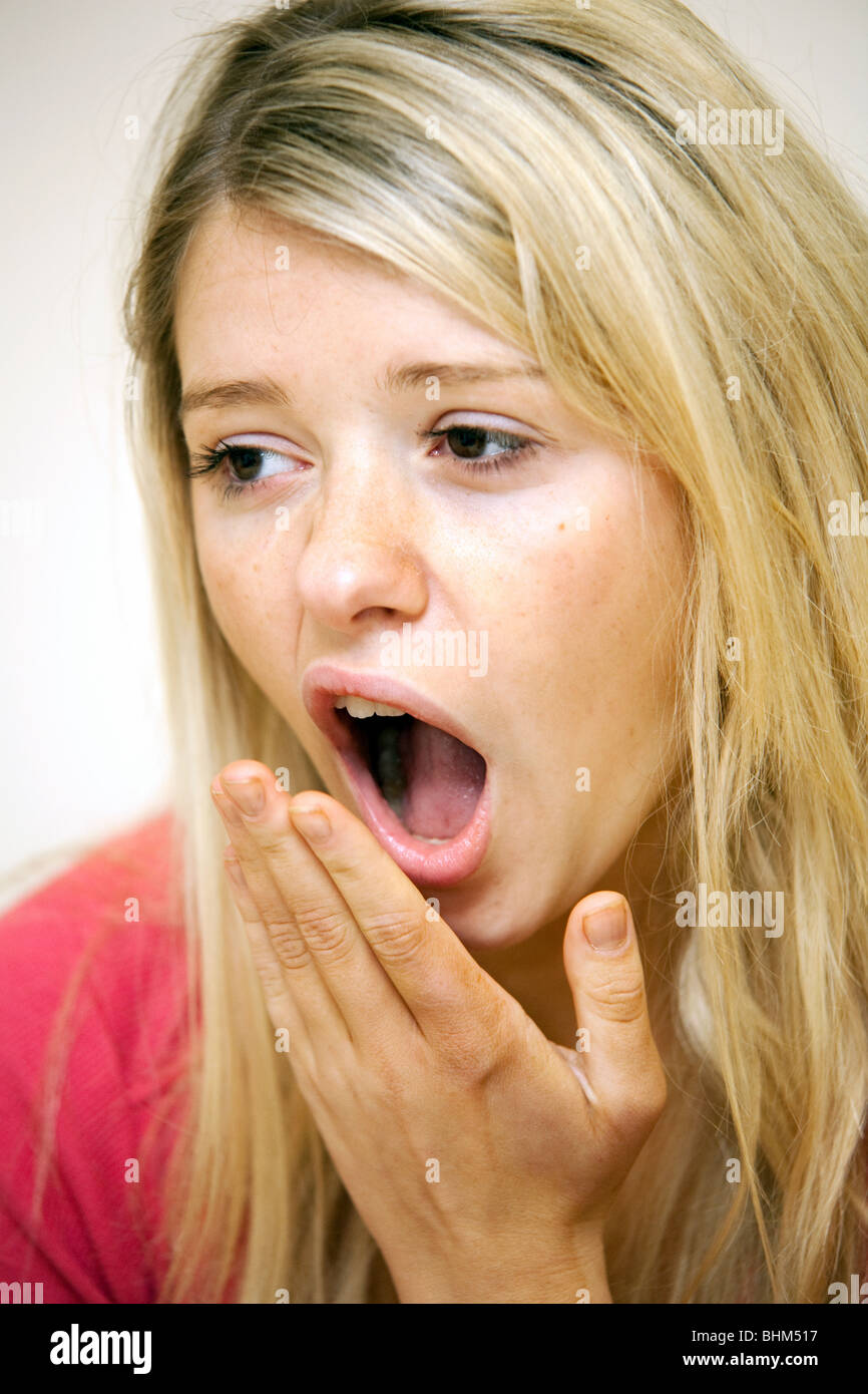 Attractive blonde teenage girl yawning Stock Photo