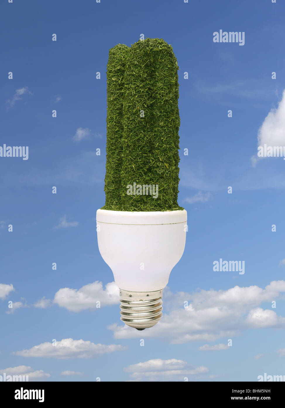 Environmentally-friendly green CFL bulb over blue sky - pure energy concept Stock Photo