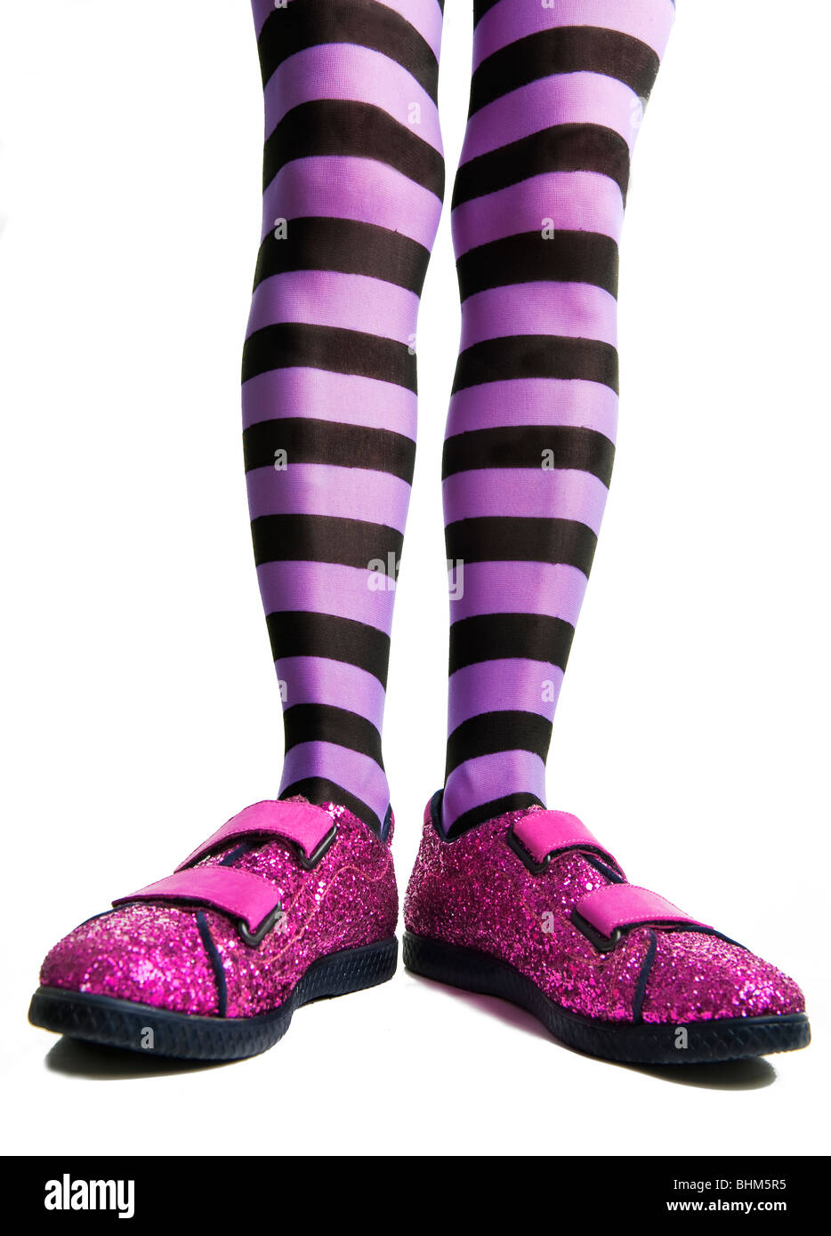 Pink sparkle shoes with woman legs in purple striped tights or pantyhose Stock Photo