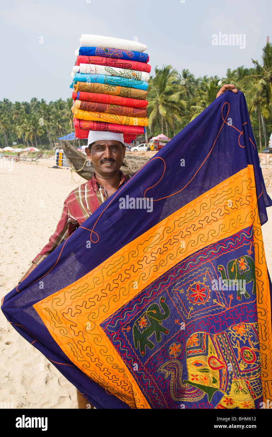 Hawker on Kovalam Beach carrying tablecloths on his head, Kovalam, Kerala, India Stock Photo