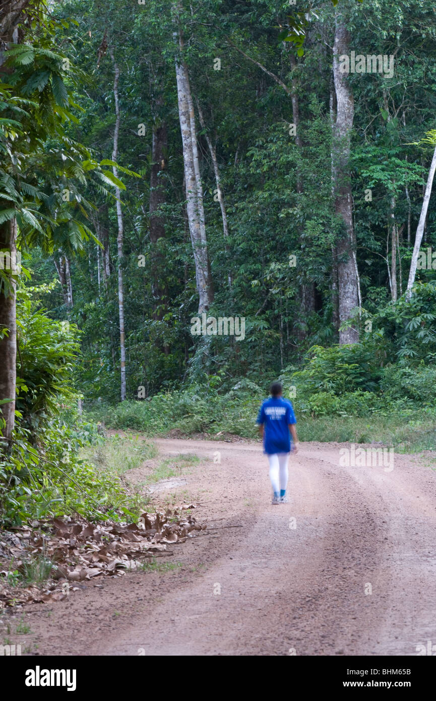 Woman walking on the road near Iwokrama Rainforest Centre Guyana South America October Stock Photo