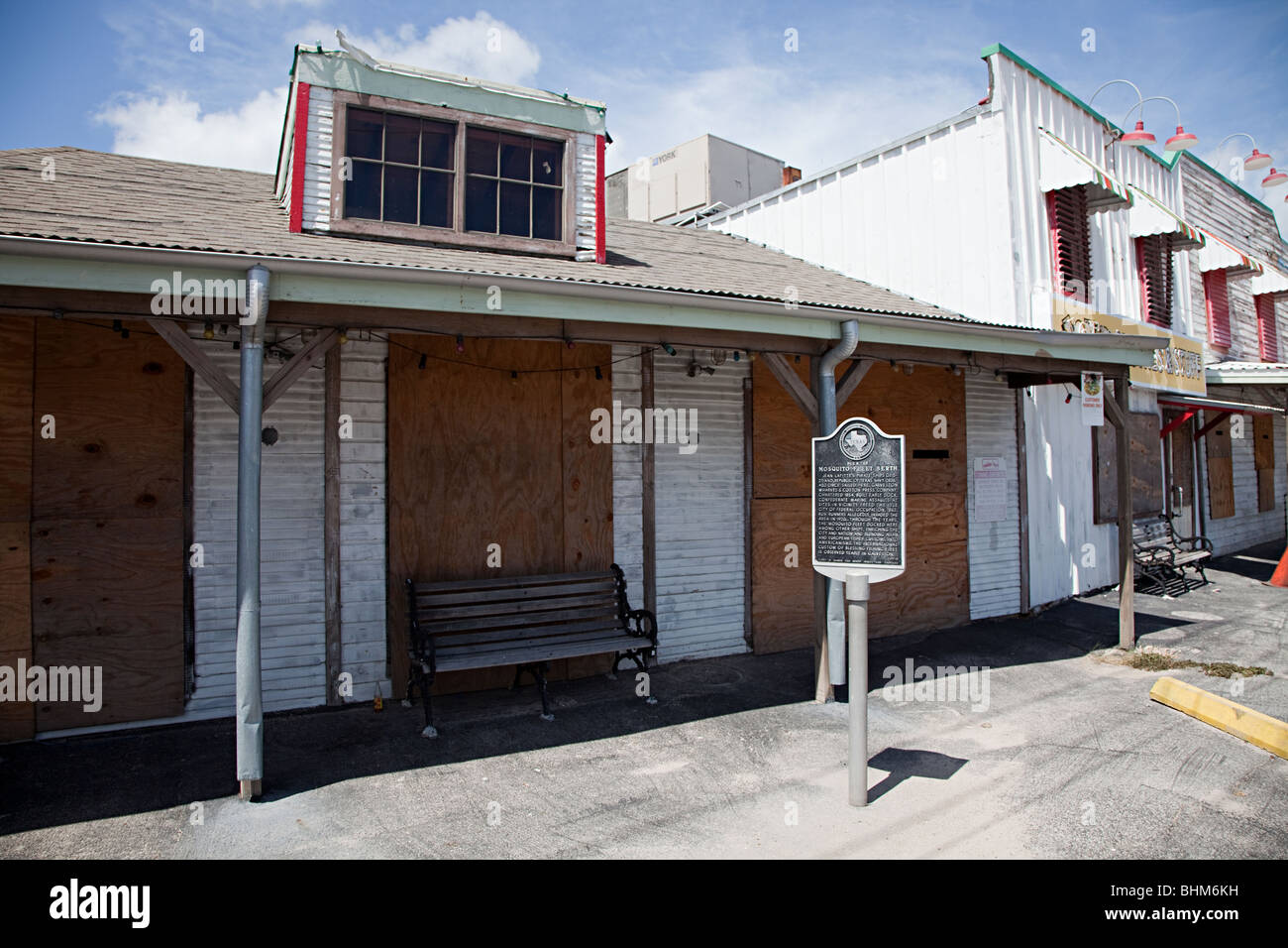 Boarded up closed shops on wharf Pier 19 with information sign Galveston Texas USA Stock Photo