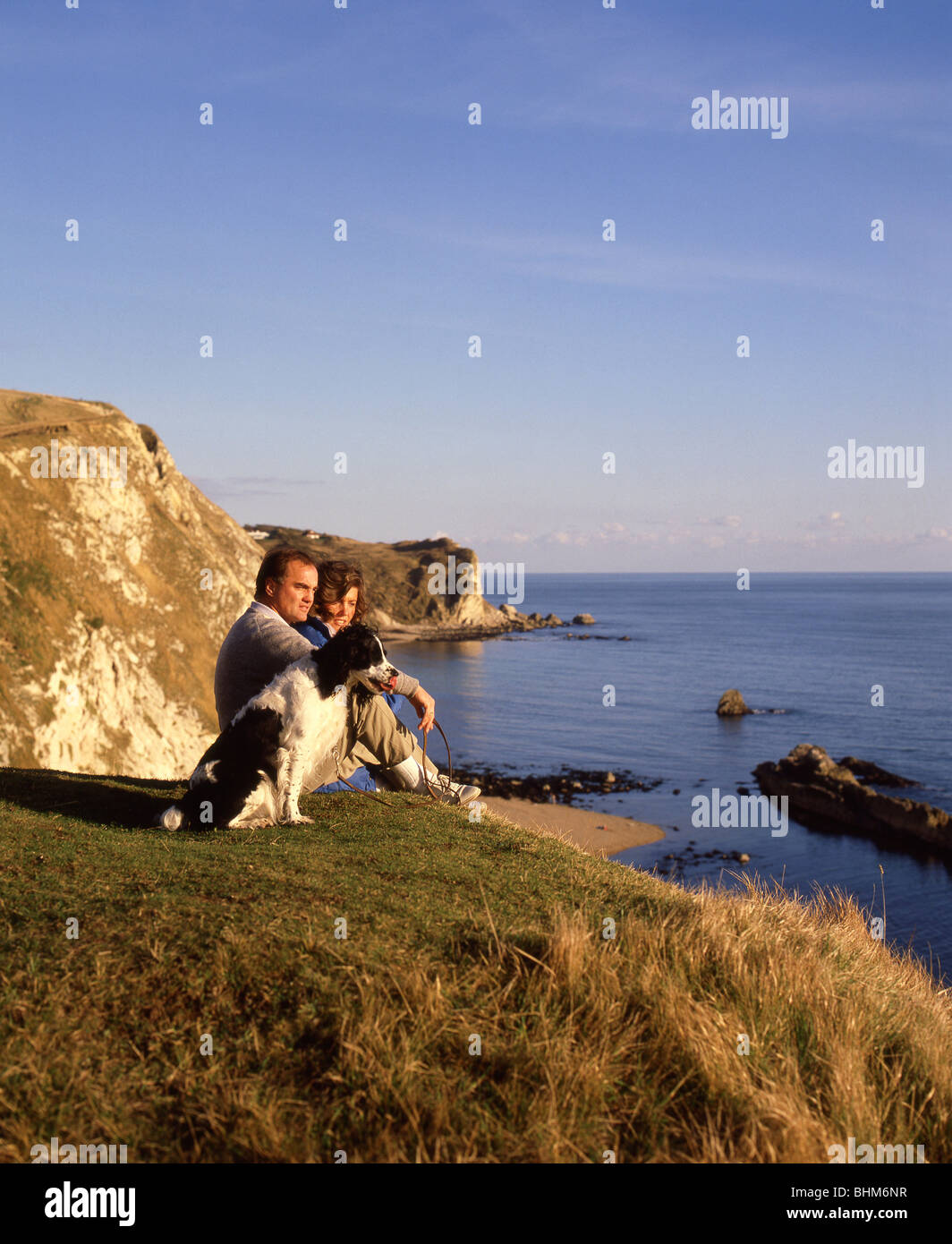 Couple sitting by coastal path, Man O'War Cove, Jurassic Coast, Dorset, England, United Kingdom Stock Photo