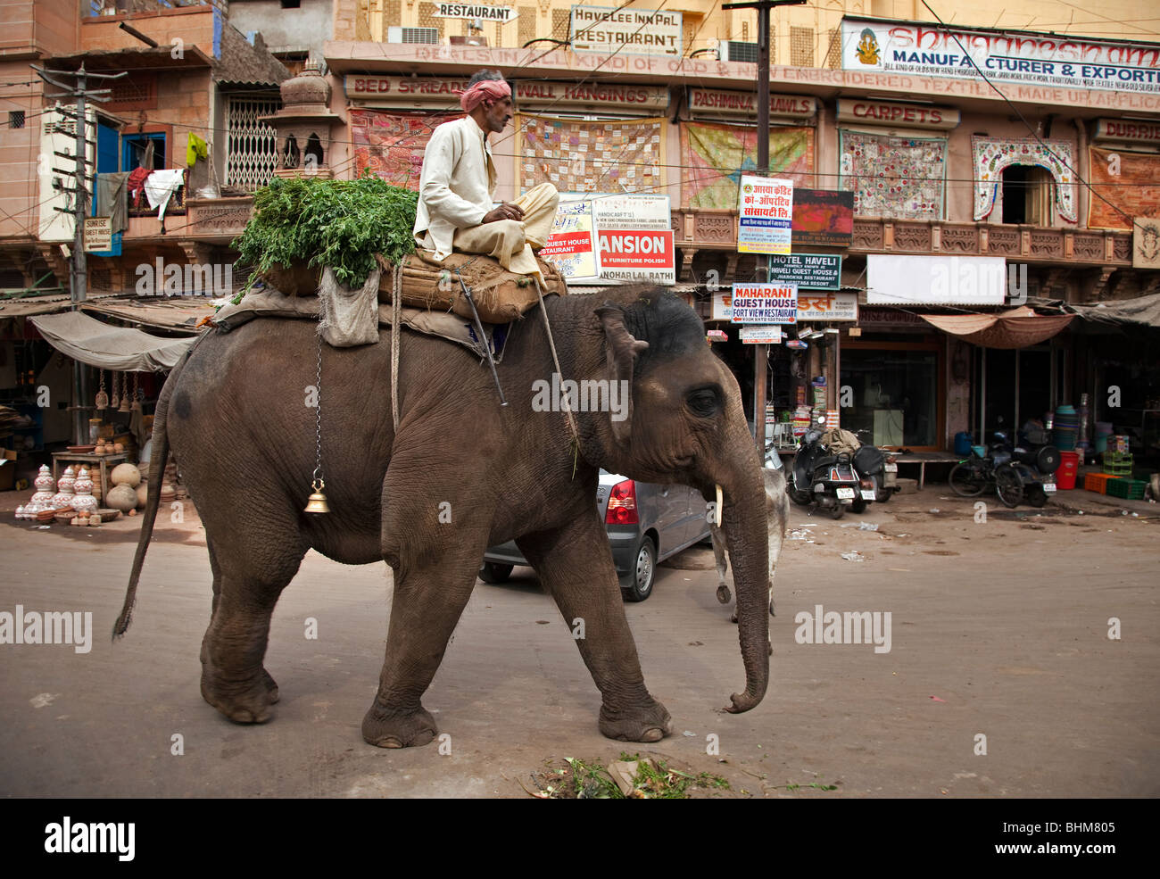 An elephant and its mahout wander the market in the Rajasthani city of Jodhpur India . Stock Photo
