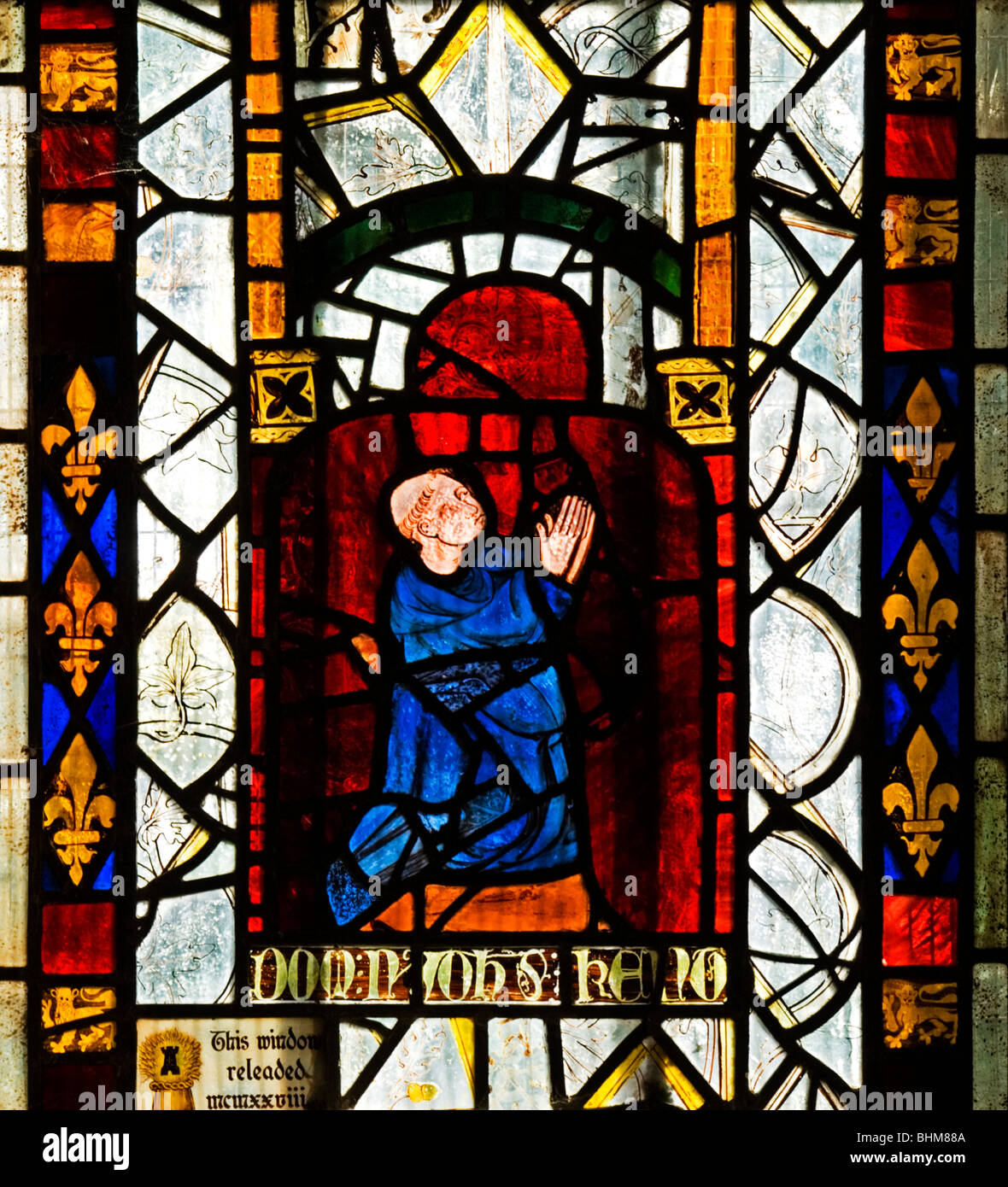 Medieval stained glass depicting a male kneeling in prayer Stock Photo -  Alamy