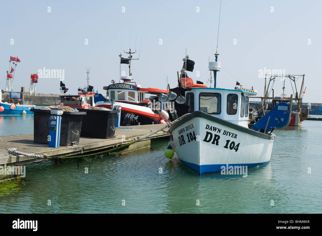 Fishing boats in the Royal Harbour at Ramsgate, Kent, United Kingdom. The large crates are used