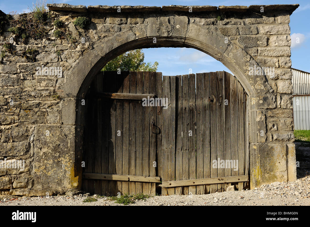 old gates in a stone arch way wood wooden wall Stock Photo