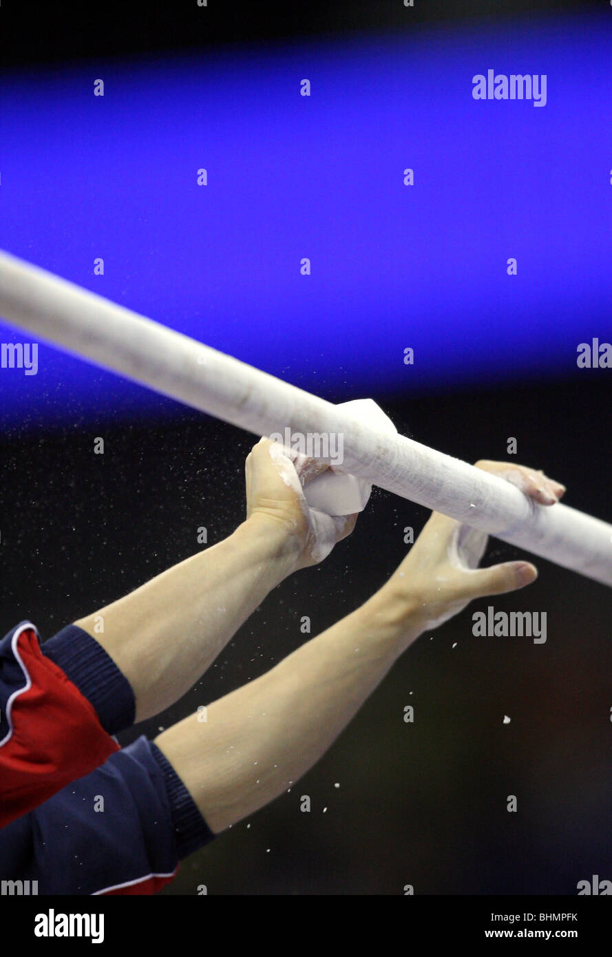 pair of hands apply chalk to the high bar of the Asymetric gymnastic
