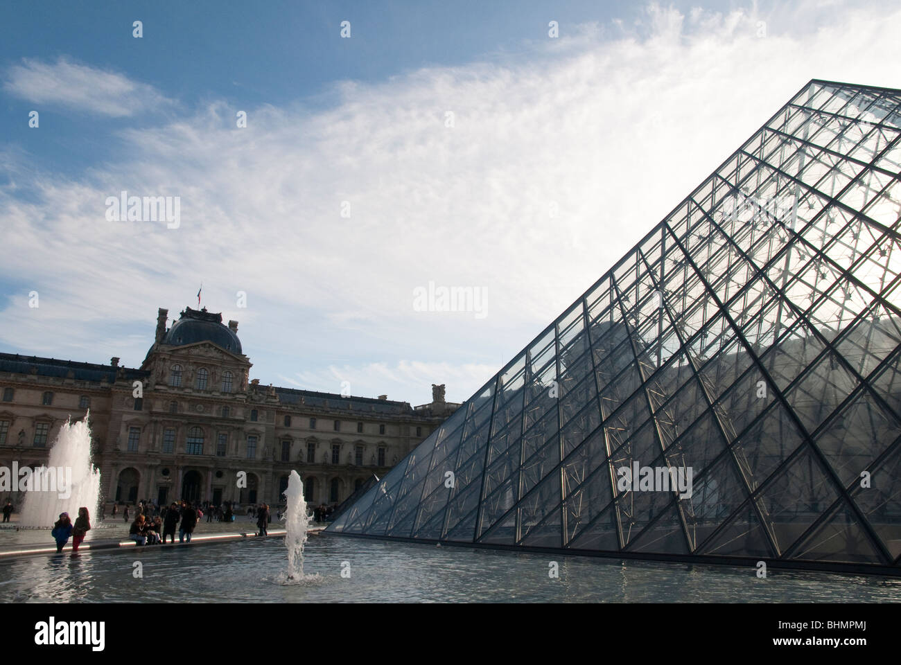louvre glass pyramid in Paris viewed with fountains and main buildings ...
