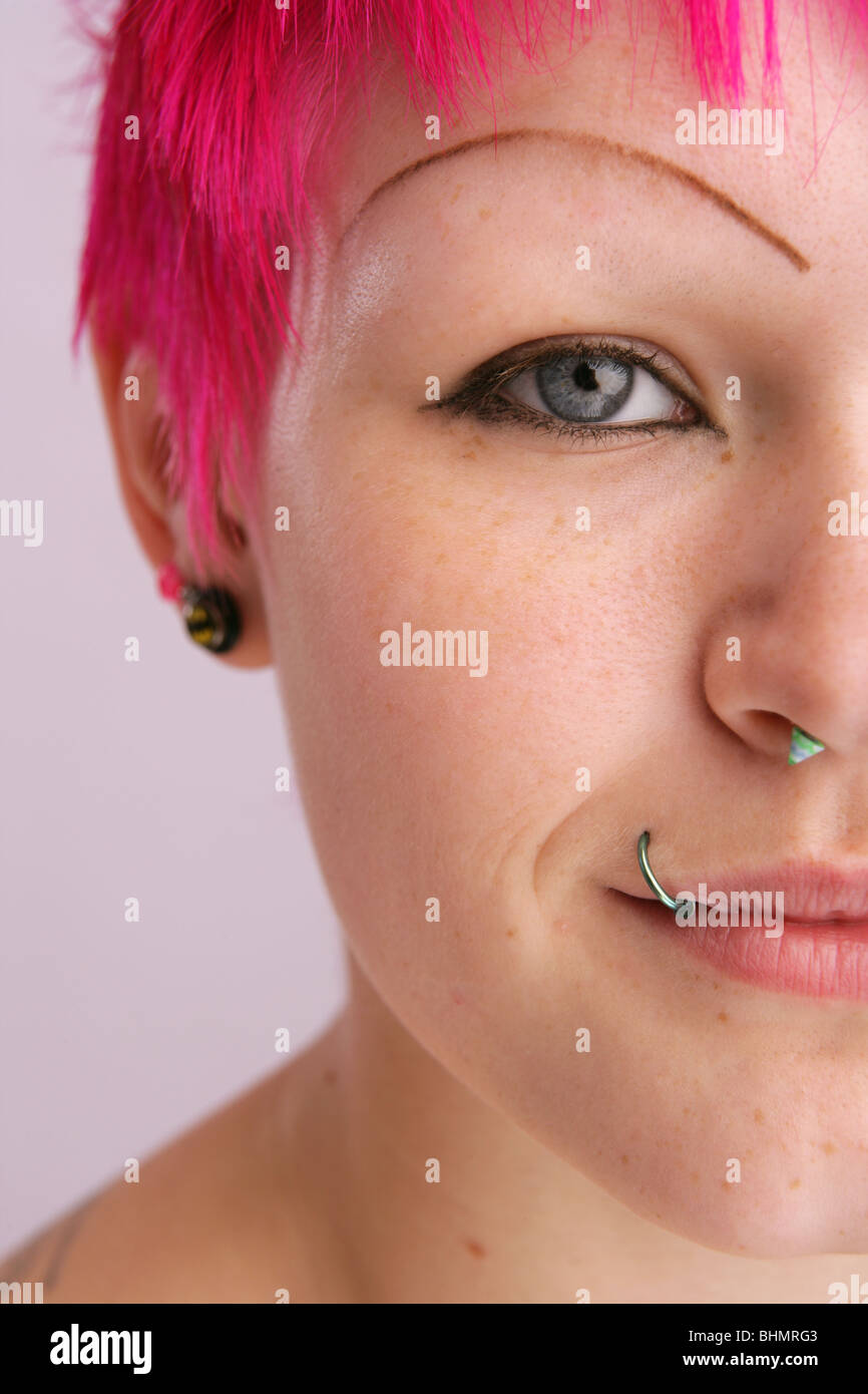 close up of a young womans face showing lip and nose piercings. Stock Photo